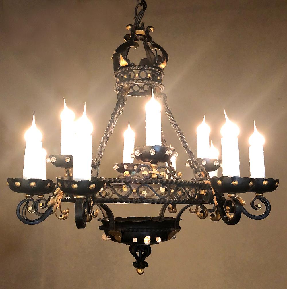 Maison Jansen style French wrought iron chandelier brings the style to the fore with inspiration drawn from the Renaissance in France, with exuberant scrollwork, fleurs de lys, gold highlights and even faceted crystals. The bowl at the bottom is