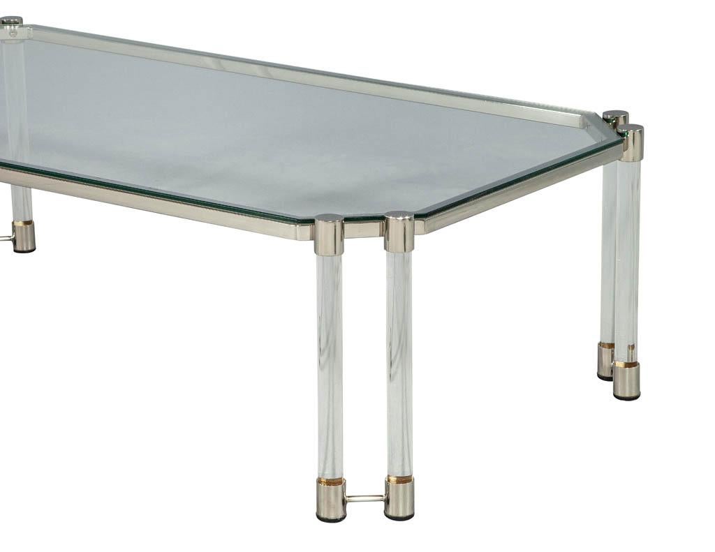 In the style of Maison Jansen, this excellent modern style cocktail coffee table features a combination of clear glass, stainless steel accents and acrylic tubular legs. Imported from Paris, France and restored by the Carrocel professionals. Please