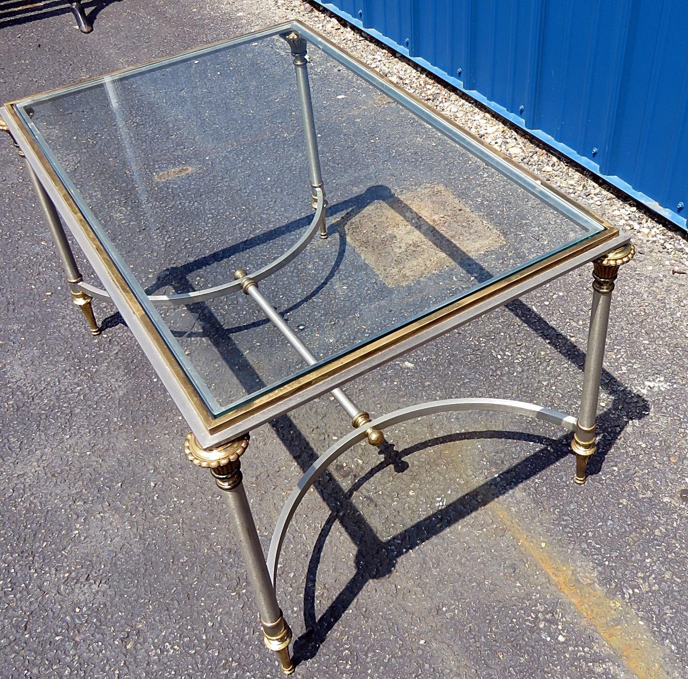 This is a great small size brass steel and glass coffee table. Done in the timeless style of Maison Jansen, This gorgeous table is fitted with a brass and steel frame as well as simple Directoire or Louis XVI details. Perfect for a chic apartment