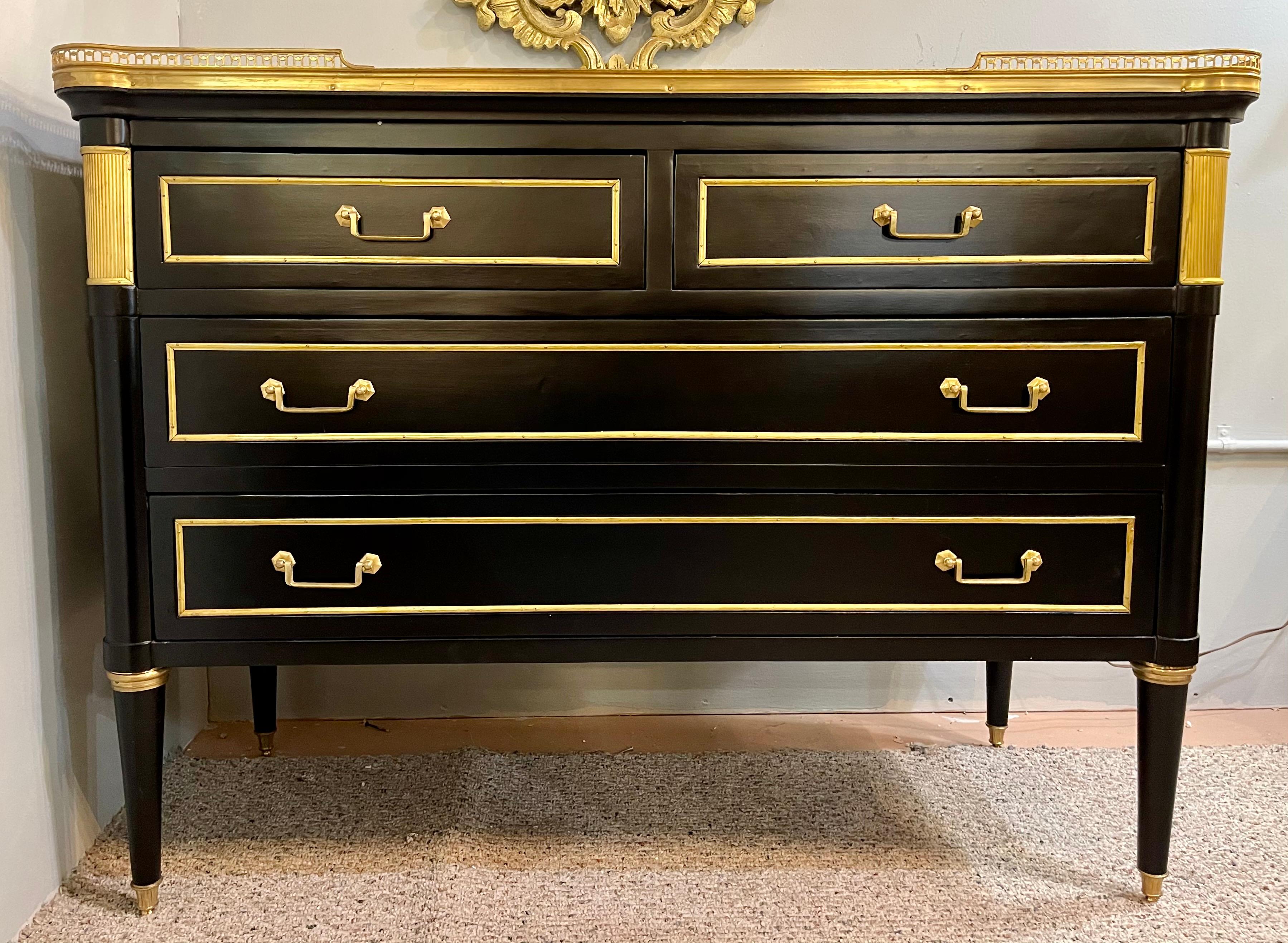 Maison Jansen style Hollywood Regency commodes, chests or nightstands. A pair of ebony simply stunning bronze mounted two over two-drawer commodes. Each having a white marble top set in a pierced bronze gallery. The ebony case having rounded corners