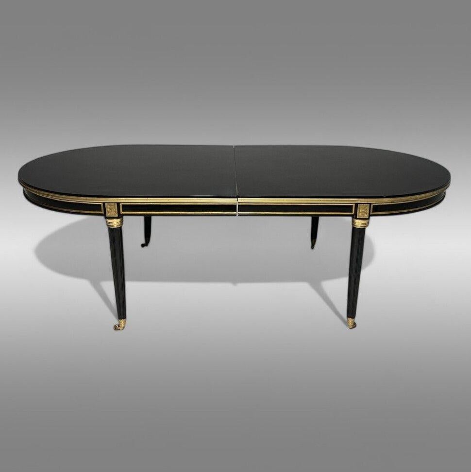 Maison Jansen Style, Louis XVI, Hollywood Regency, Table de salle à manger, Laque noire, Bronze

Une impressionnante table de salle à manger laquée ébène avec une monture en bronze, comprenant deux (2) feuilles insérables de 22 pouces pour une
