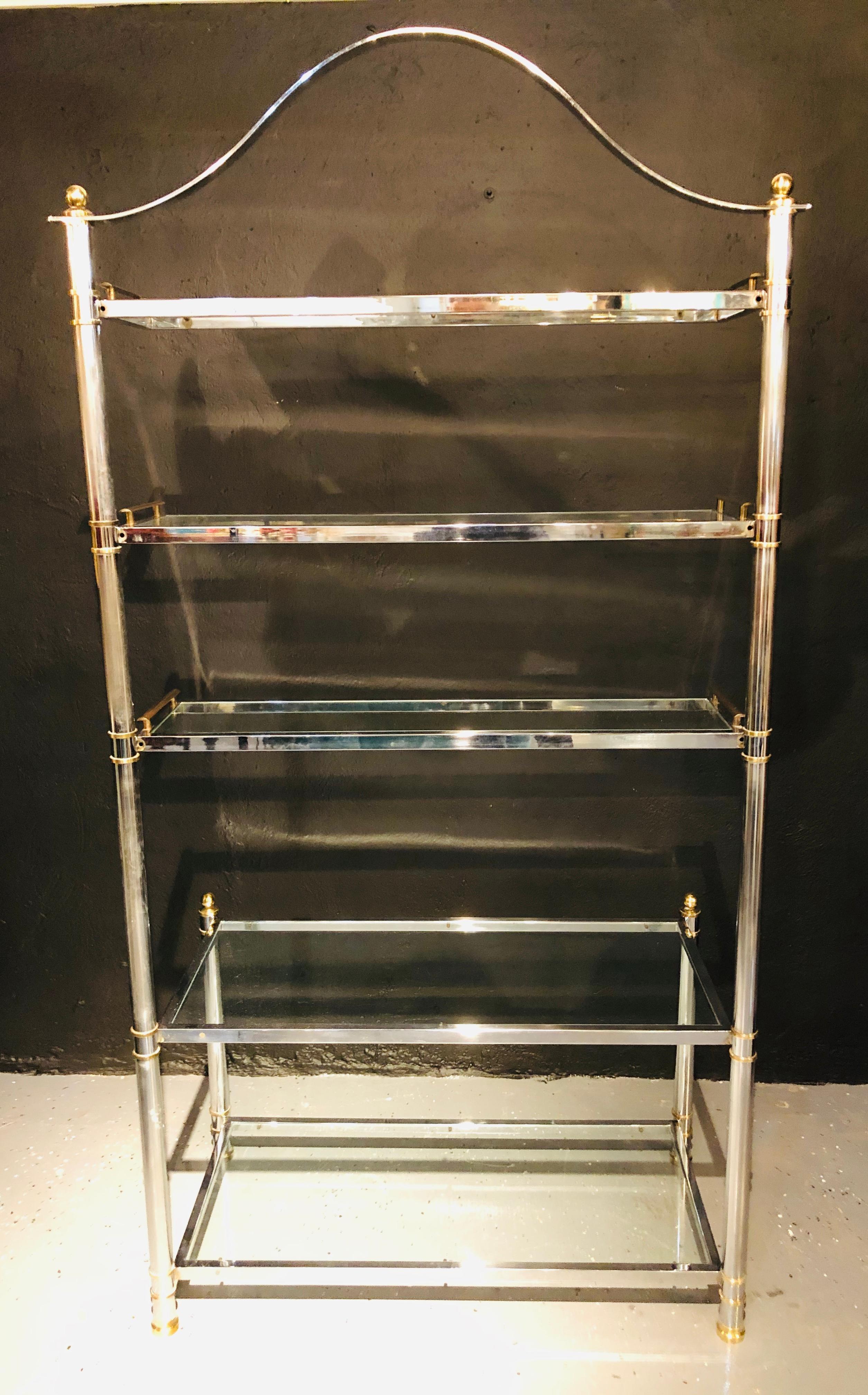Maison Jansen style Hollywood Regency étagère or bookcase. Having a brass and steel design this stunning example of a finely cast five shelf bookcase or étagère depicts the era of Hollywood glitz and glamour at its peck. The two lower shelves about