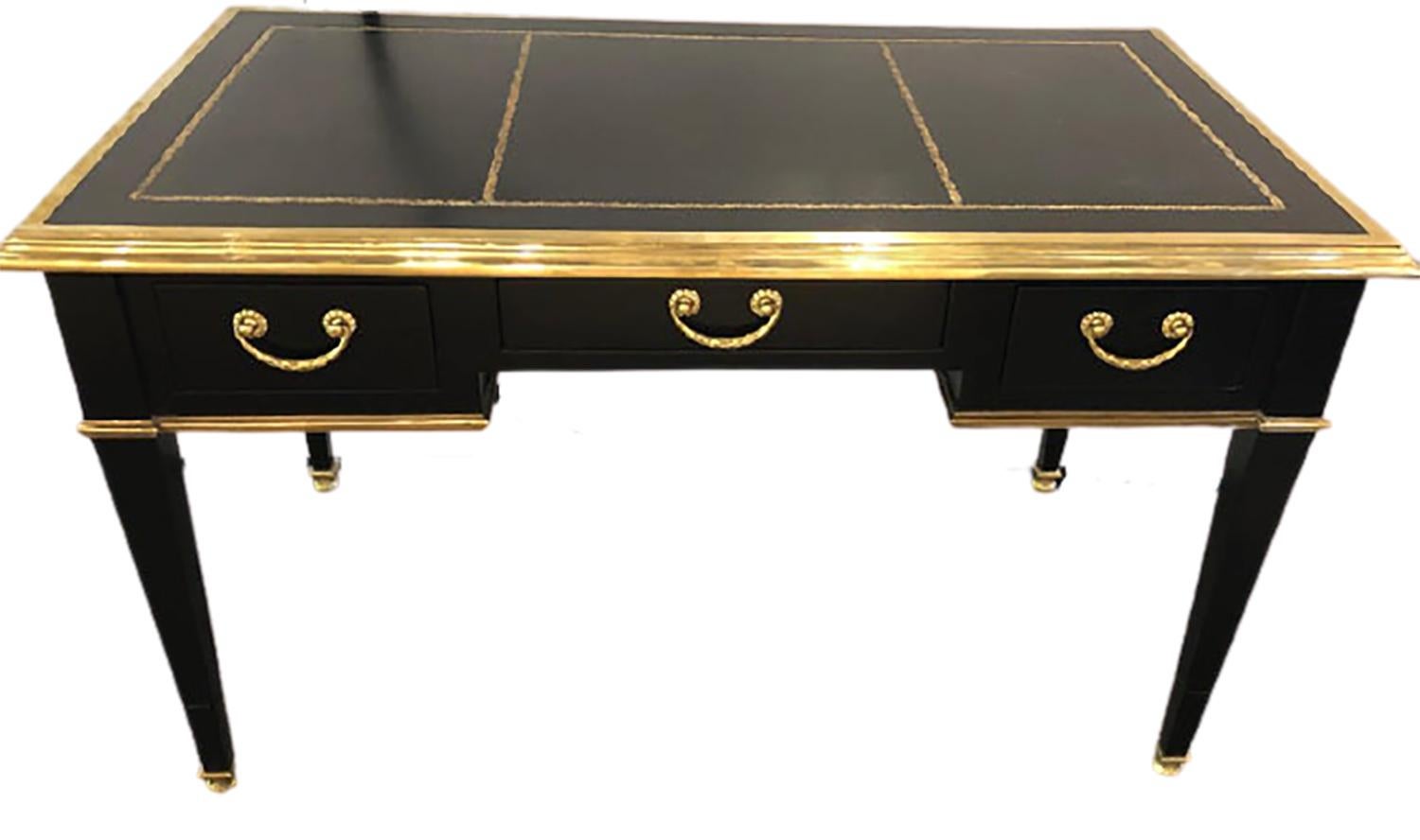 A Maison Jansen Hollywood Regency style writing desk in ebony with bronze mounts having oak secondary’s. This early desk having a thick bronze framed galleried leather tooled tabletop is simply stunning. Having been recently refinished and all the