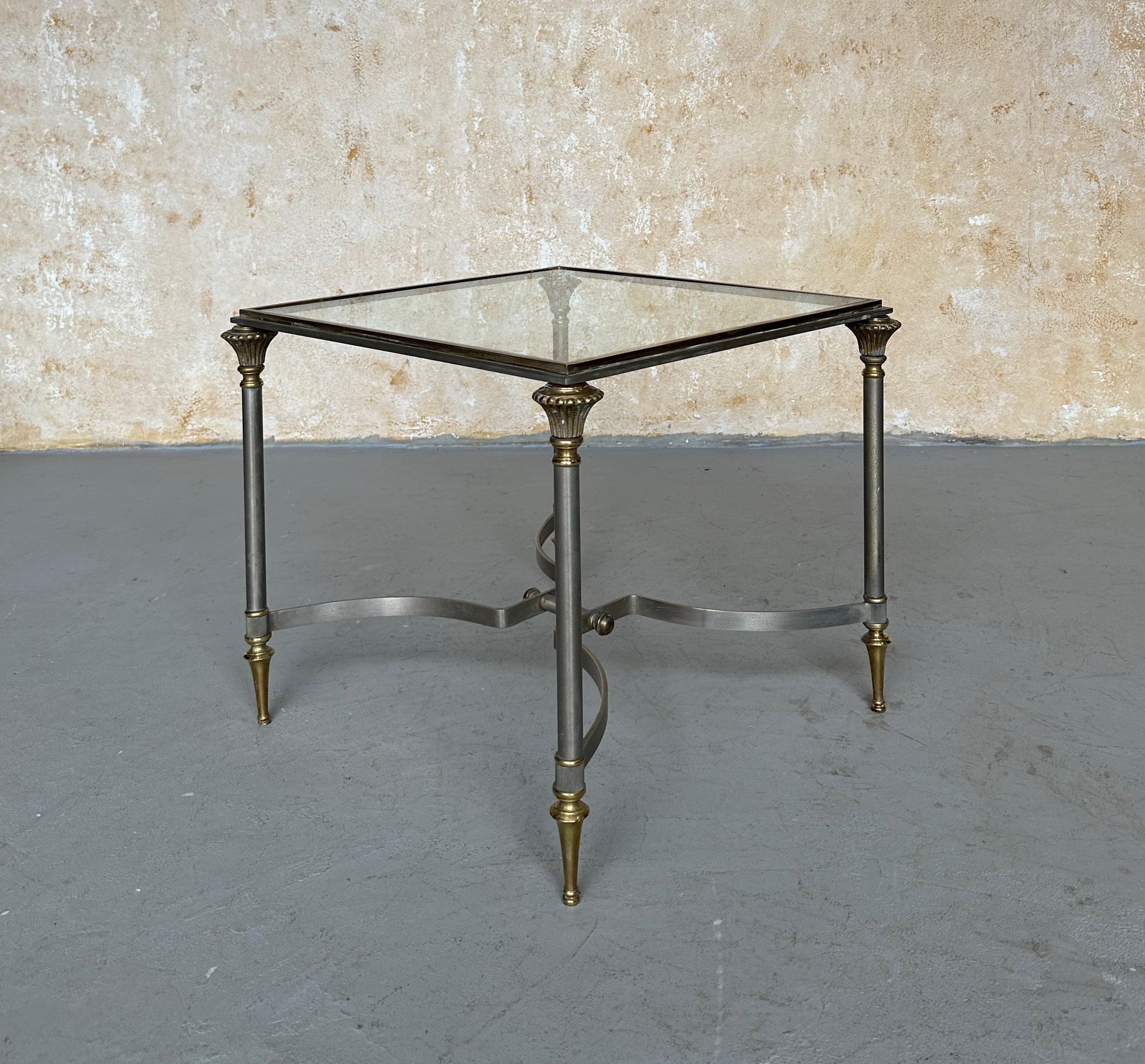 Dieser elegante italienische Beistelltisch aus den 1940er Jahren wurde im Stil von Maison Jansen gefertigt und zeichnet sich durch sorgfältig gearbeitete Stahl- und Messingelemente sowie eine eingelassene Glasplatte aus. In gutem Vintage-Zustand,