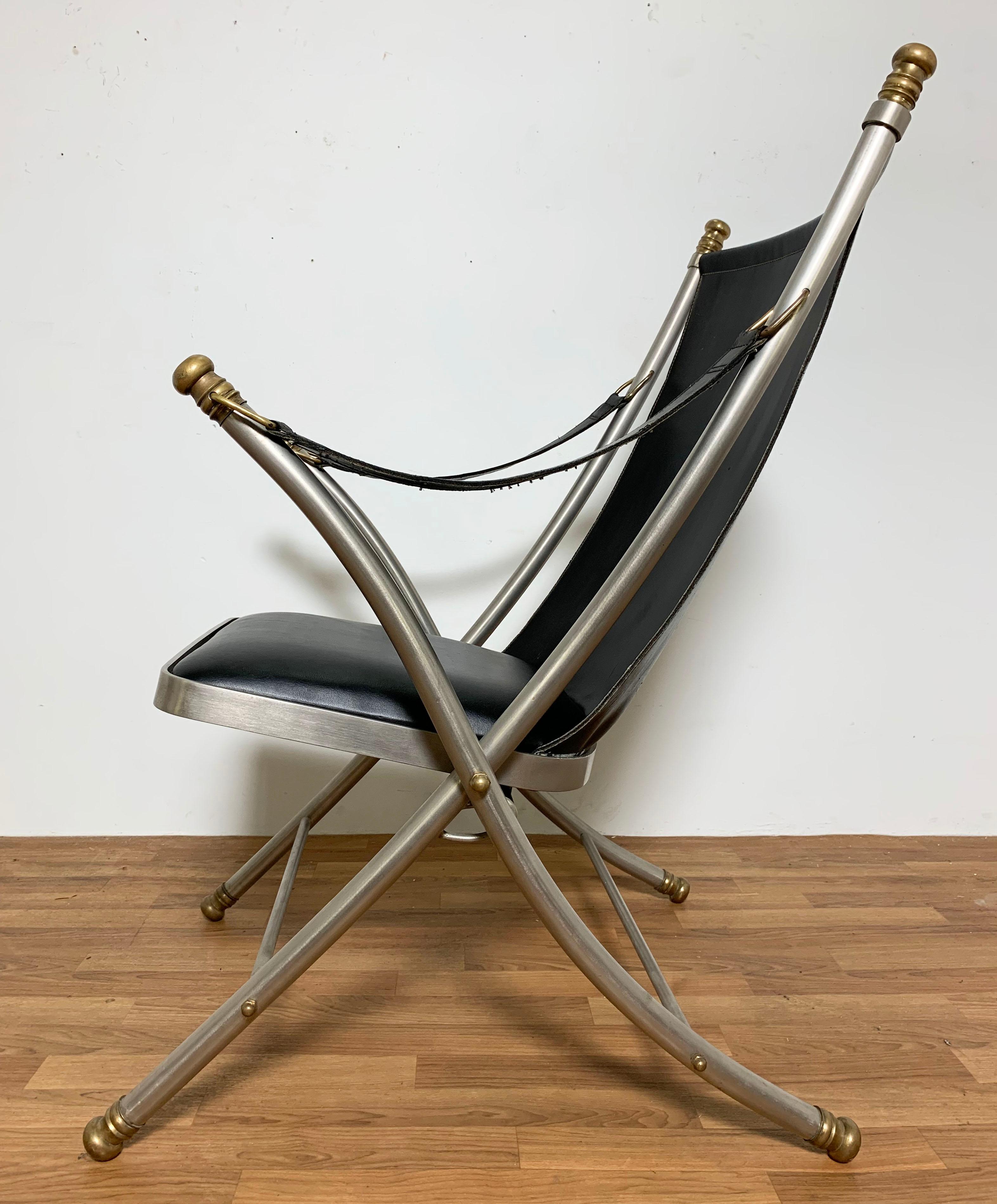A folding campaign chair in mixed metals with leather upholstery in the style of Maison Jansen, circa 1960s.