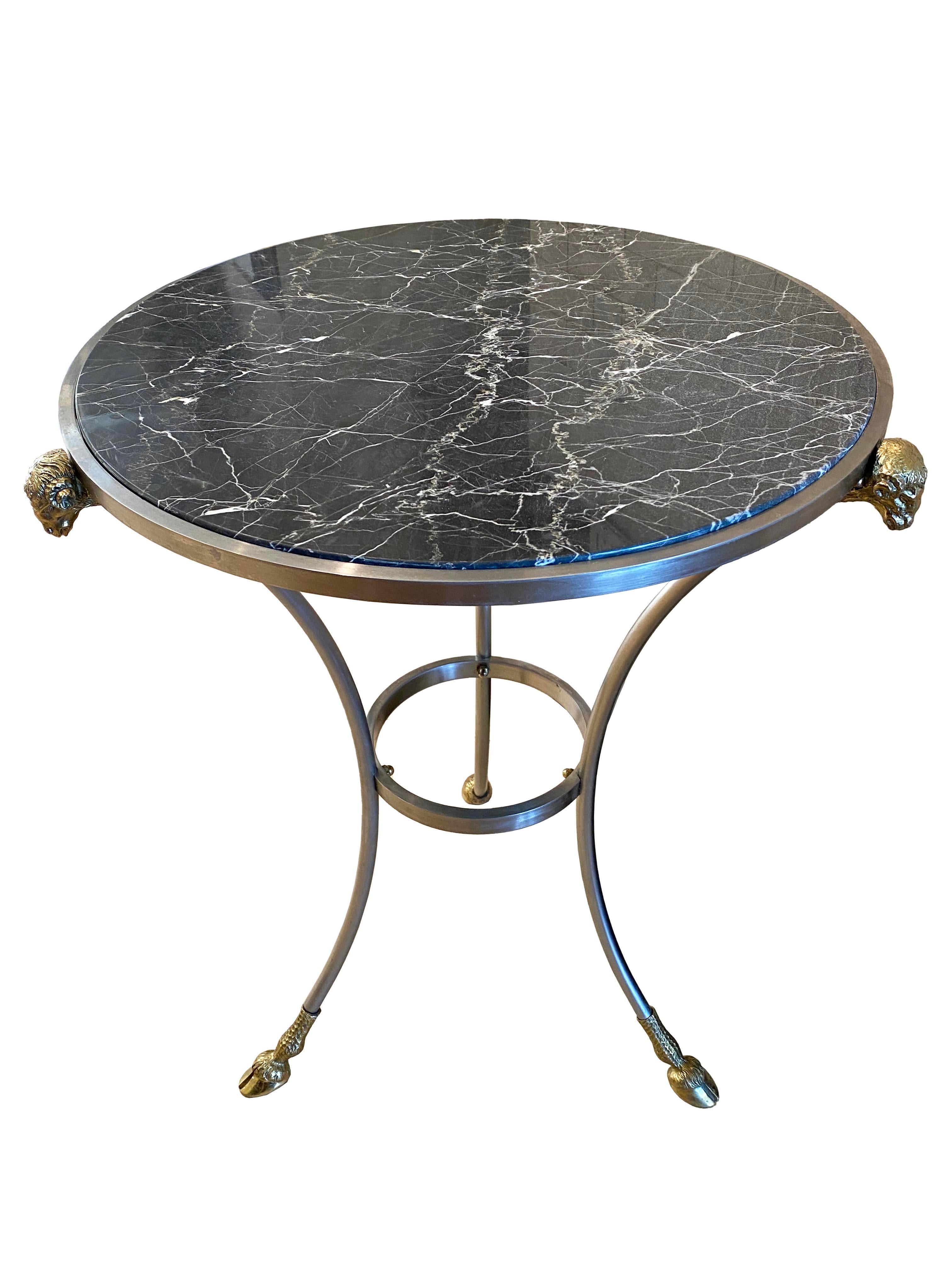 Añade un toque de elegancia atemporal a tu hogar con esta mesa auxiliar de estilo Maison Jansen, exquisitamente elaborada en Italia. Con una lujosa encimera de mármol negro grisáceo con llamativas vetas blancas, esta pieza encarna la refinada