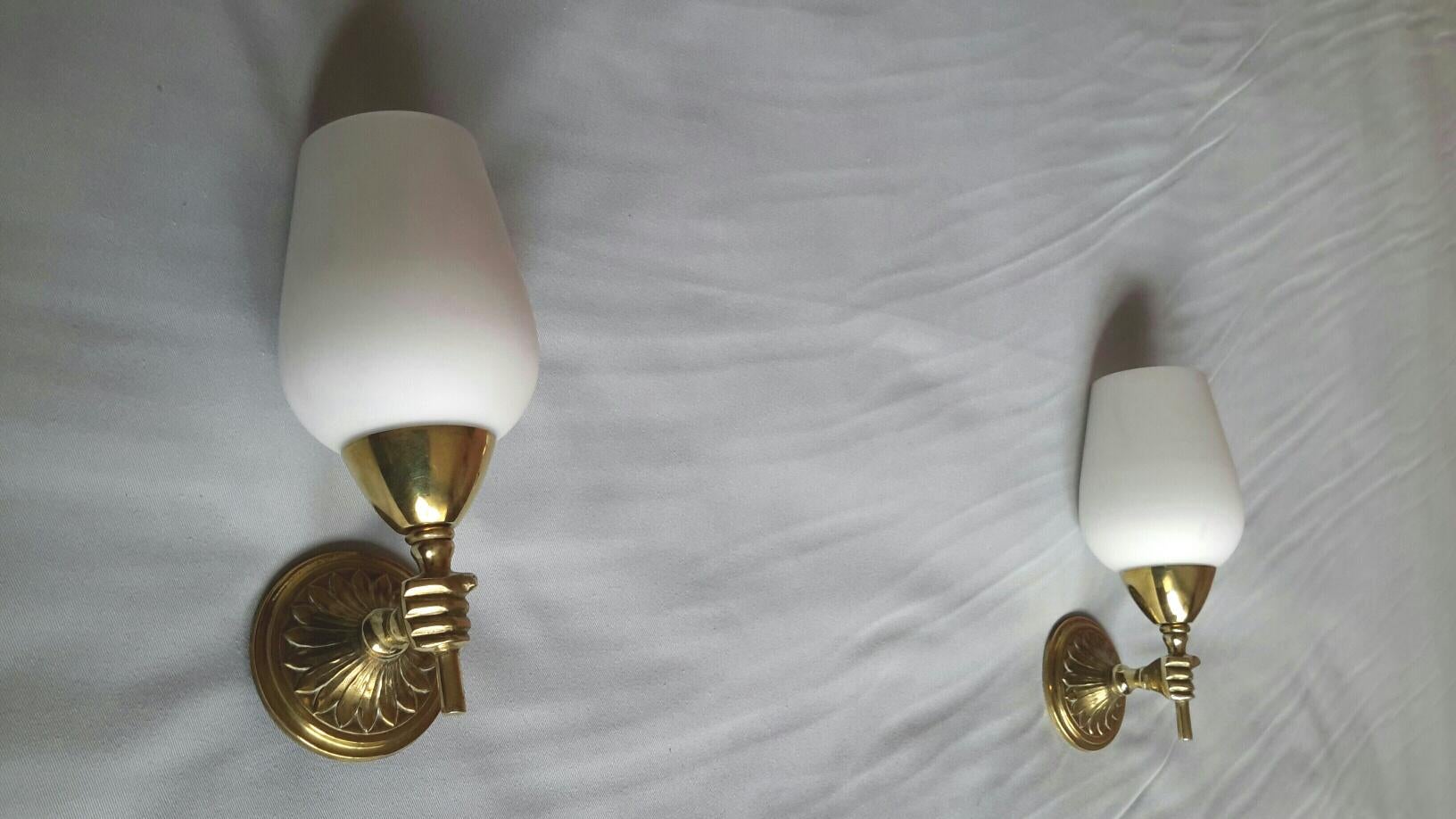 Charming original pair of neoclassical bronze sconces with white opaline lampshades tulips and figuring small hands torchere holding it in the style of the French Maison Jansen, France, circa 1950.
In a very good condition, rewired to fit the US