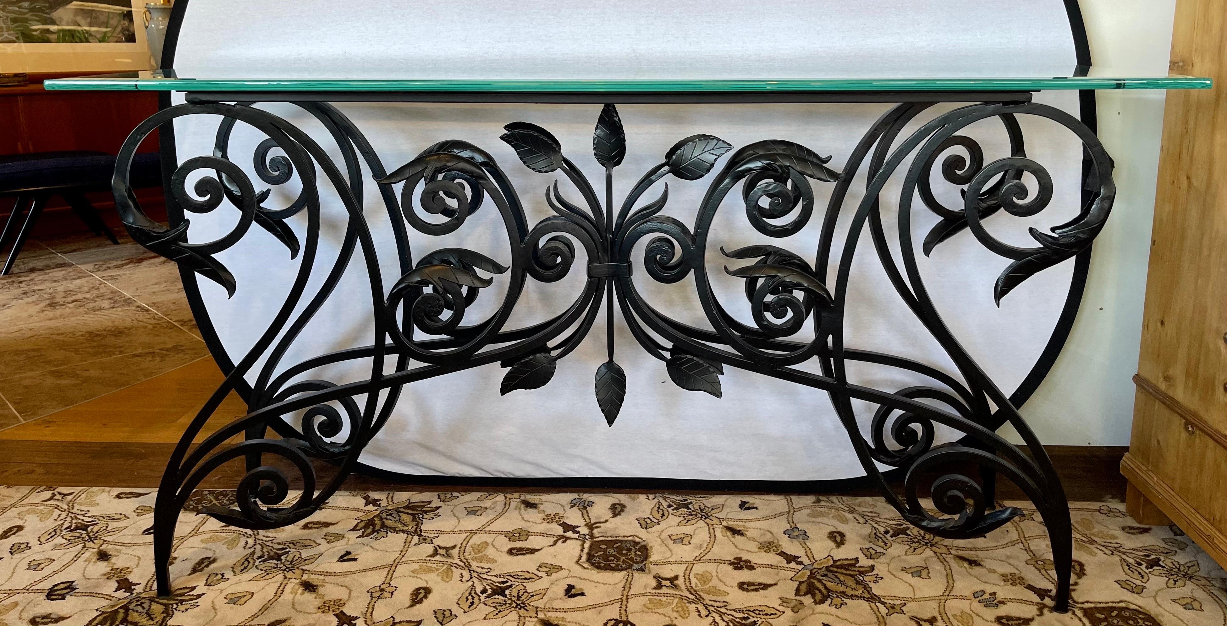 Stunning custom Maison Jansen style iron and glass console table with out of this world detail to iron sculptured base.  The base alone weighs 120lbs and the glass top, which is .75 inches thick, weighs an additional 70lbs.  A one of a kind