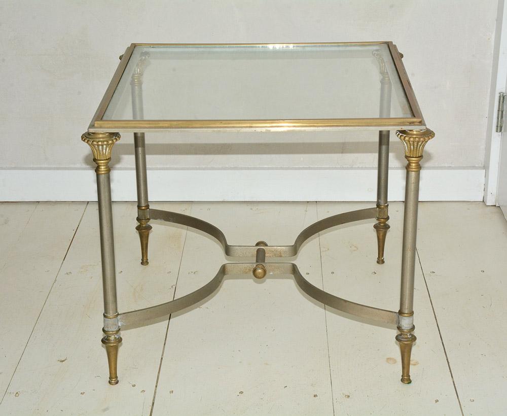 Neoclassical Revival, petite Maison Jansen style steel and brass coffee table with inset glass top and original patina, circa 1960s. Please note of wear consistent with age including minor oxidation on the metal trim and minor scratches on the glass