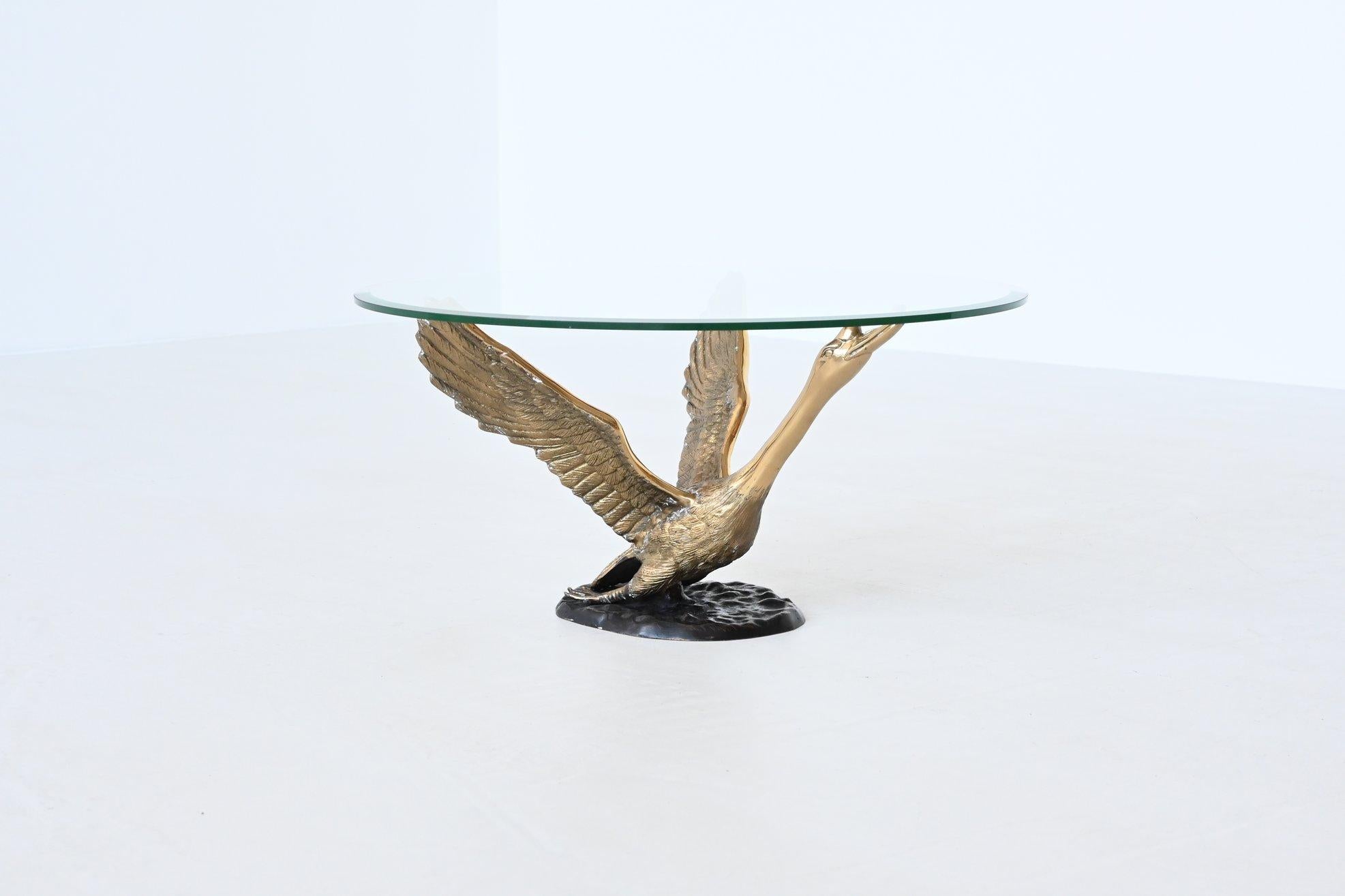 Beautiful and elegant swan shaped coffee or side table designed and manufactured in the style of Maison Jansen, France 1970. This table features a base of a bronze flying swan that supports a thick round glass top. It is in very good original