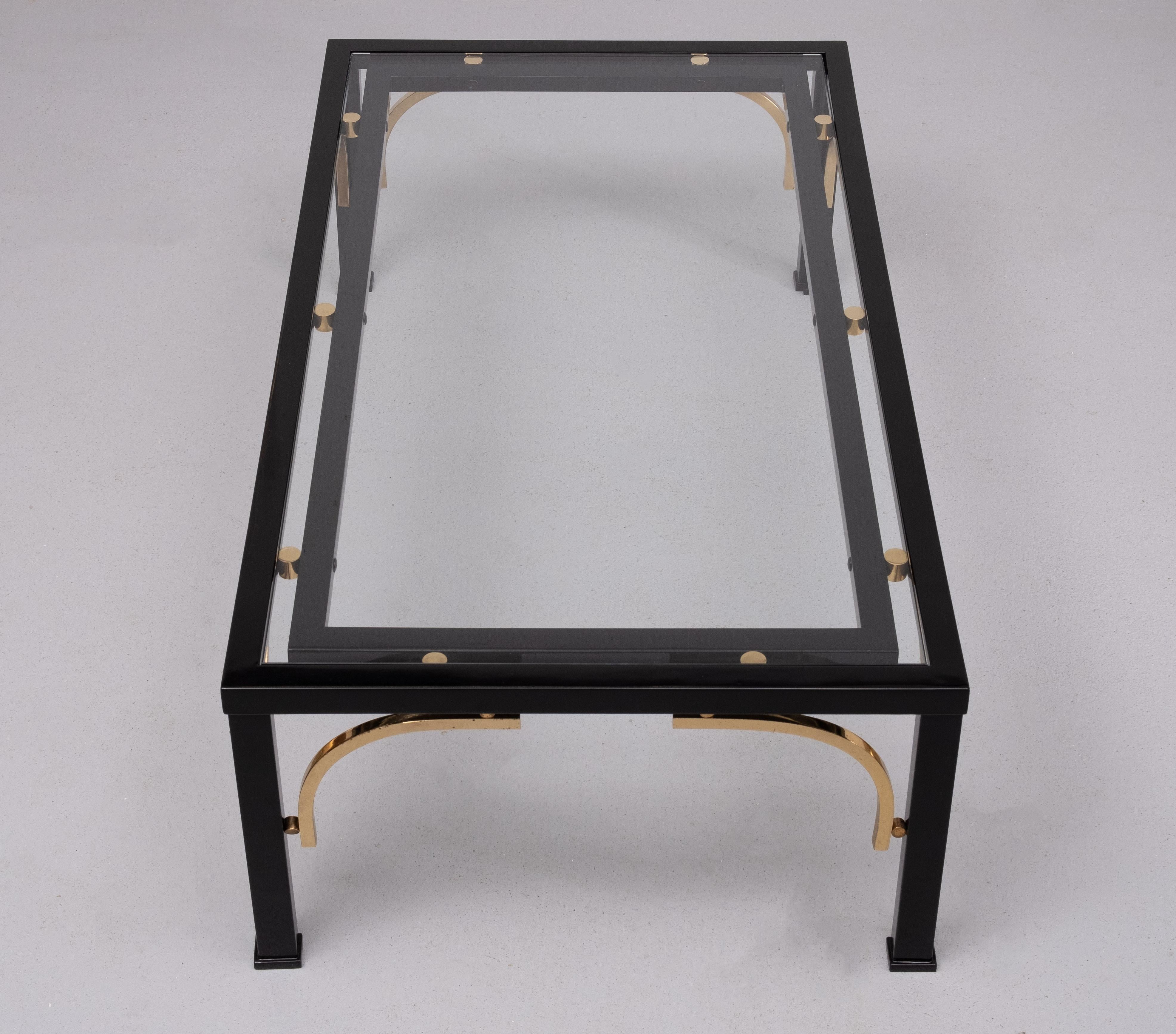 Superbe table basse en bois laqué noir, livrée avec son plateau. 
avec des arcs et des boules en laiton massif. La partie supérieure est fabriquée à partir de matériaux neufs.  Verre de 8 mm d'épaisseur .  Design/One . Bonne qualité et table unique