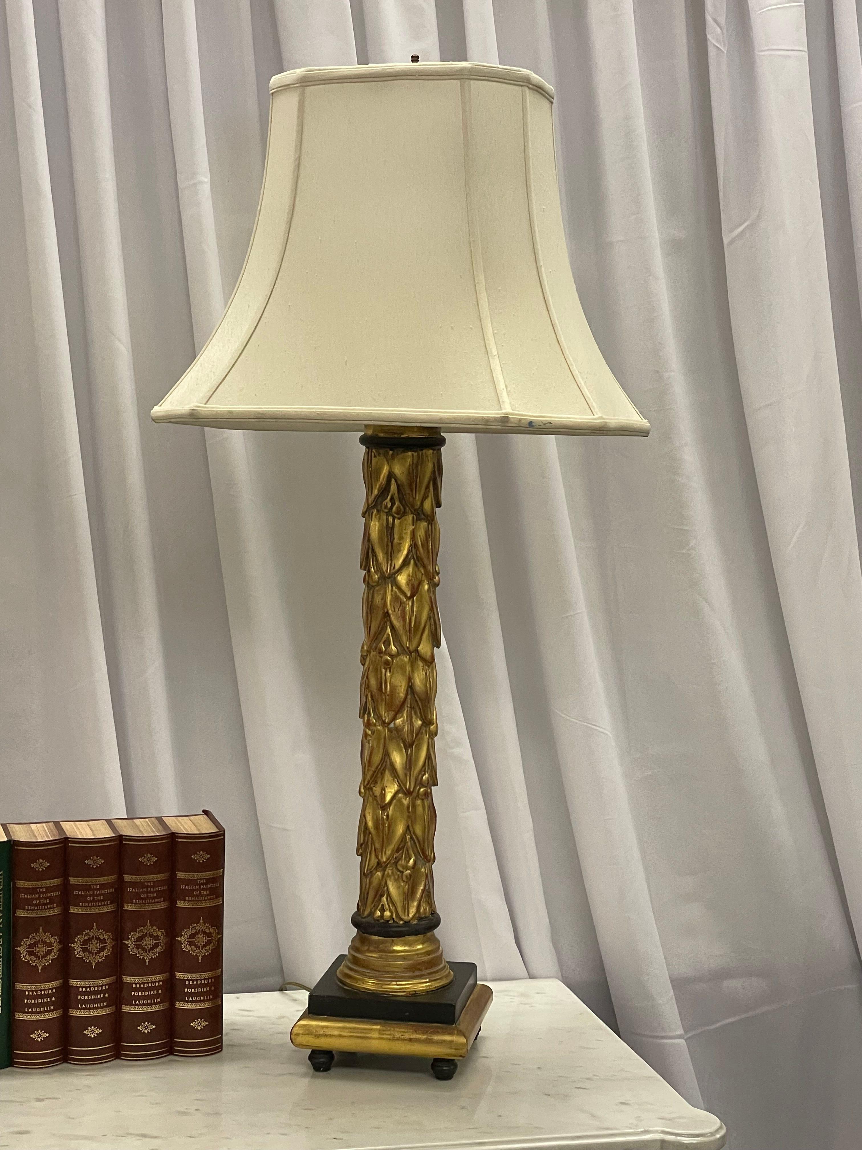 Pair of Maison Jansen table lamps having fleur de lis gilt gold and ebony design in the Hollywood Regency or Mid Century Modern Fashion. A truly stunning pair of lamps with small carved grapes inside the leafs.

Giltwood, Ebony
France, 1950s.