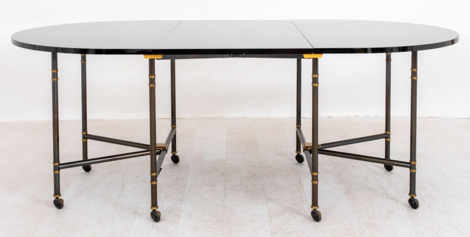 Maison Jansen 'Table Royale' model ebonized faux bamboo oval extending dining table, with black lacquered oval top and one extending leaf above steel ane ormolu framework and legs ion casters, the casters signed 