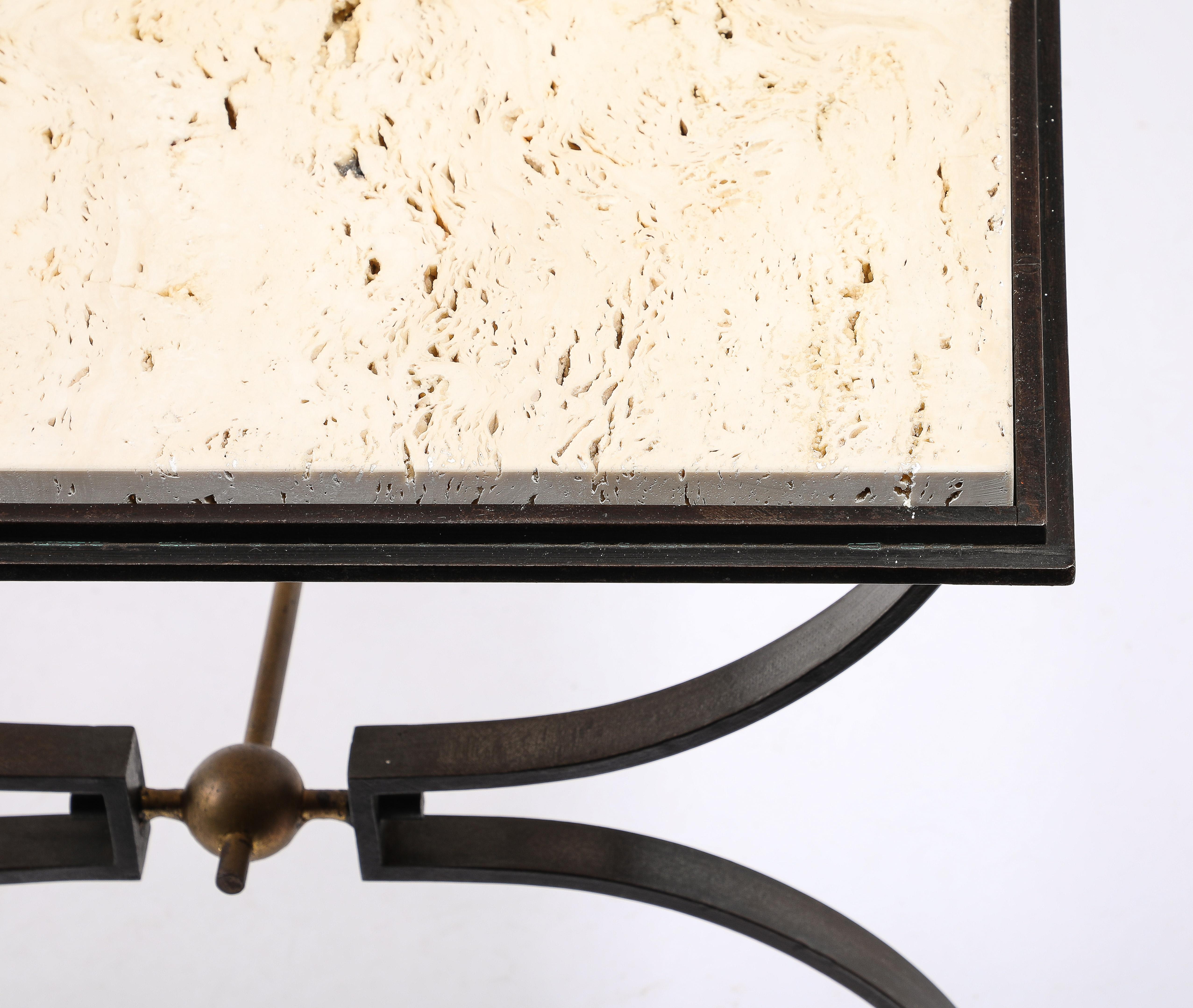 A Wrought Iron and Travertine table with a double layered top, the legs made of bent flat iron joined in the middle by a stretcher connected to a sphere.
Original patina and gilt finish.
