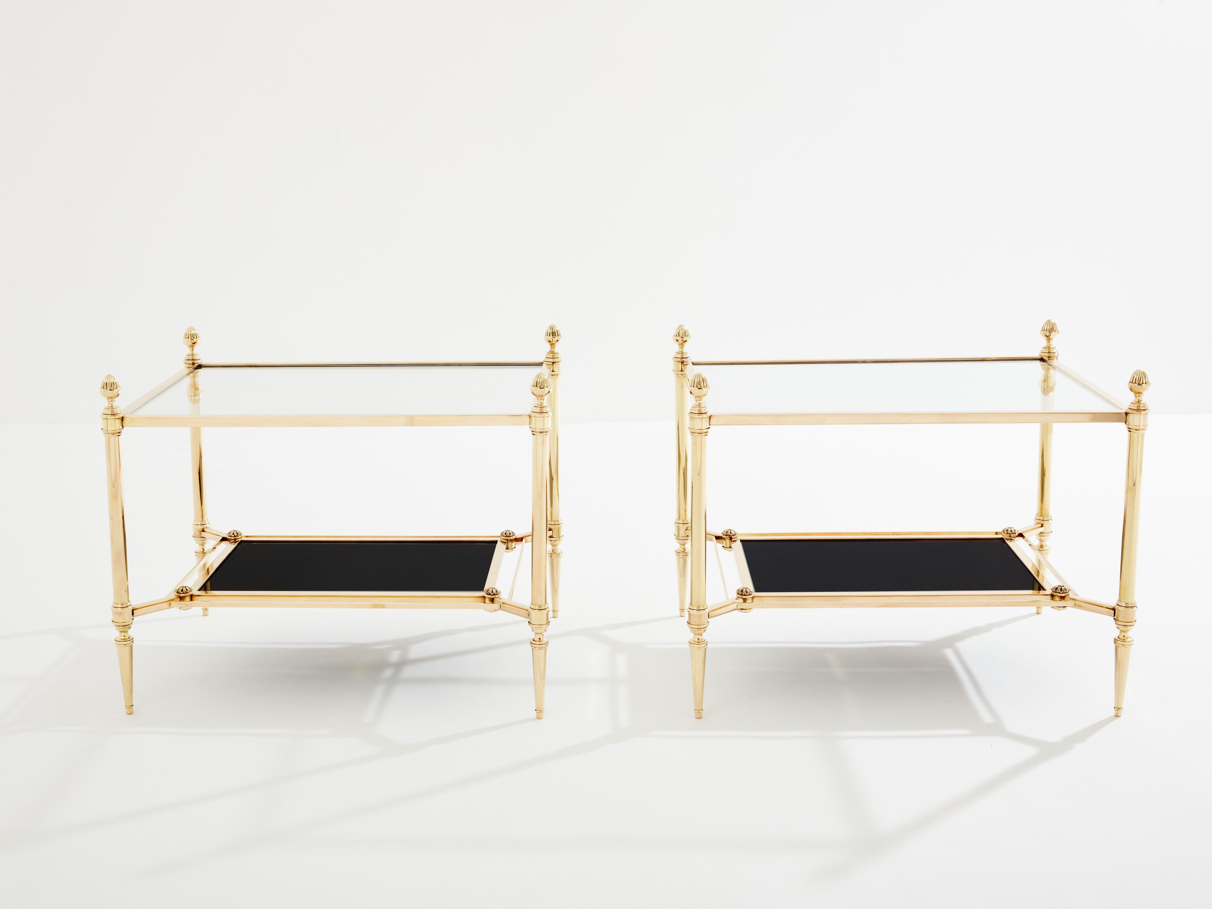 Ces magnifiques tables d'appoint à deux niveaux de la Maison Jansen ont été créées avec du laiton massif et des pommes de pin typiques du néoclassicisme français au début des années 1970. L'étagère inférieure en verre opalin noir est lisse et