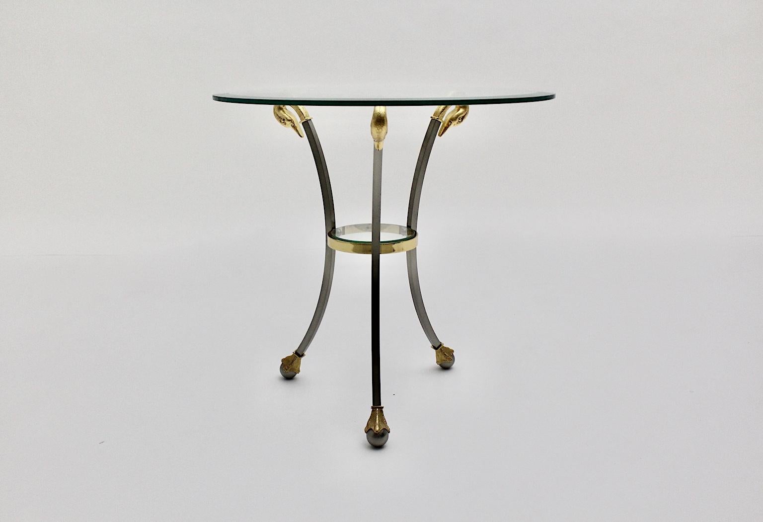 Hollywood Regency Style vintage three-legged side table from chrome-plated steel and gold plated metal by Maison Jansen circa 1980 France.
While the side table shows three slightly curved feet decorated with swan heads on the upper part and three