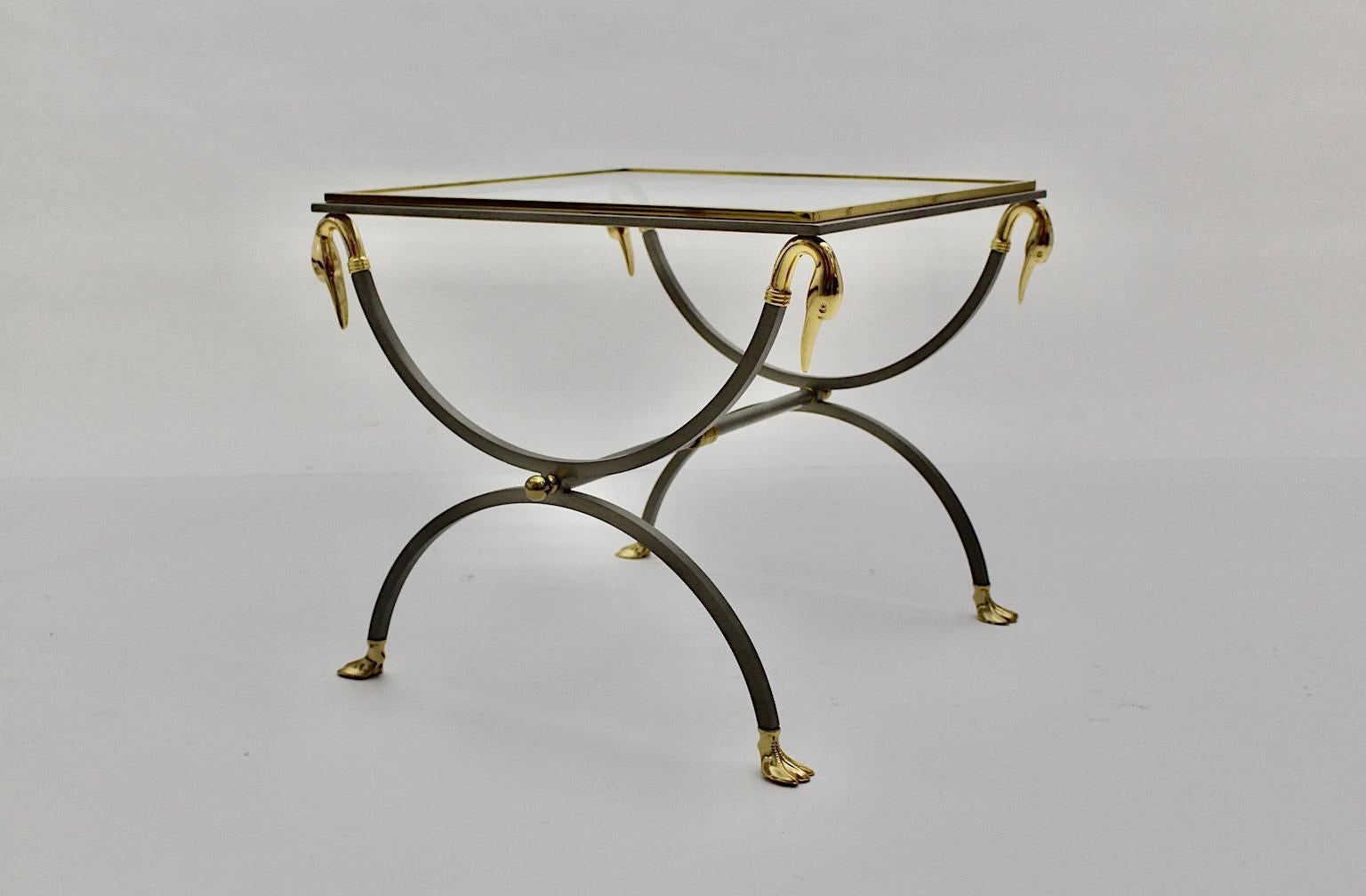  Table basse ou table d'appoint de la Maison Maison/One, conçue en France, vers 1970. La table basse de haute qualité a été fabriquée en acier inoxydable brossé et les détails dorés comme les têtes et les pieds de cygne.
Très bon état avec des