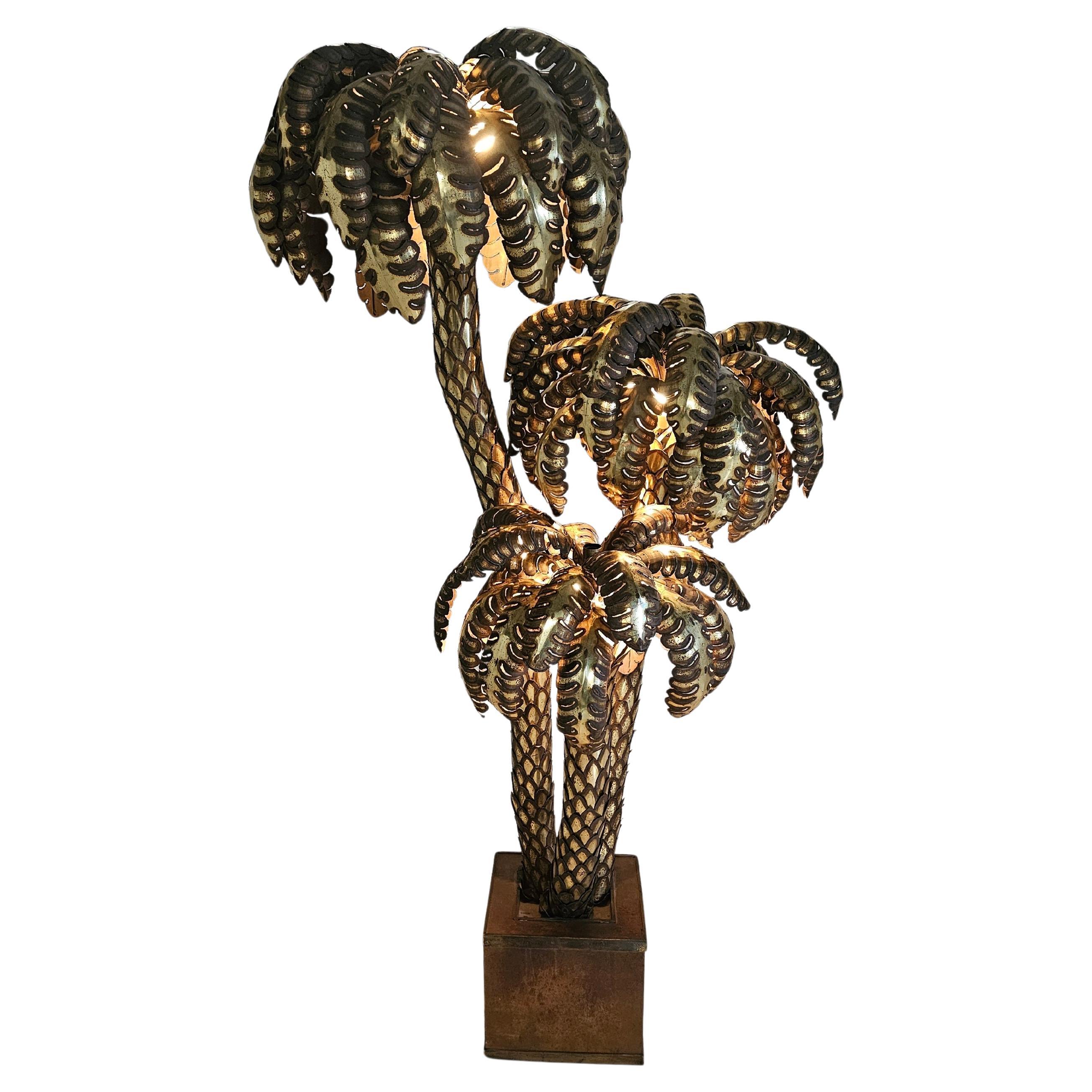 Lampe à palmier massive et rare de la Maison Jansen, France, années 1960. Tronc et feuilles en laiton patiné, taillés au chalumeau, sortant d'un socle carré en stratifié noir. Avec leurs douze points lumineux, ils diffusent une lumière chaude qui se