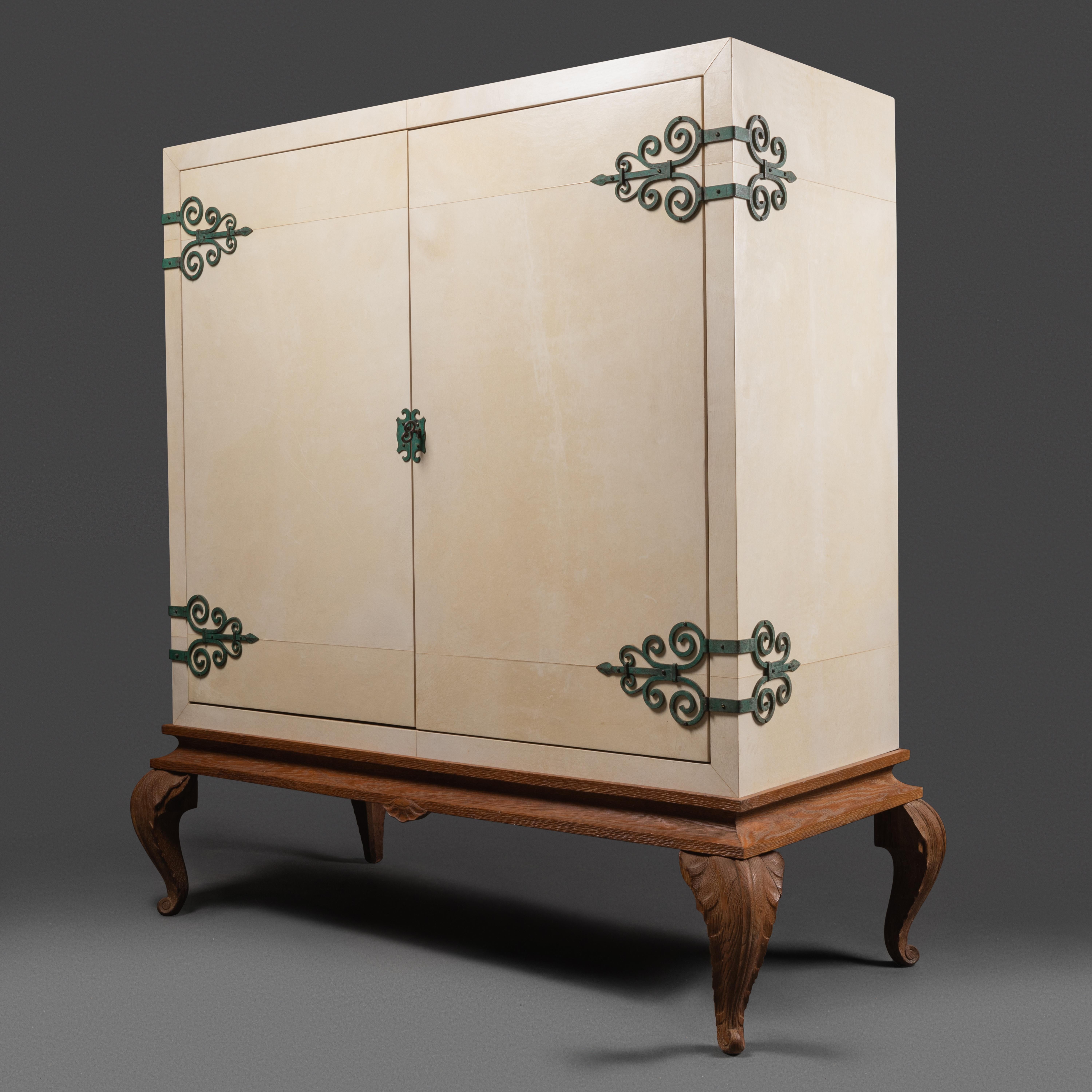 Maison Jansen 
Cabinet-Bar covered with the original parchment, rests on carved wood feet. Fitting ornaments with antique green patina. Light oak interior in perfect condition.  