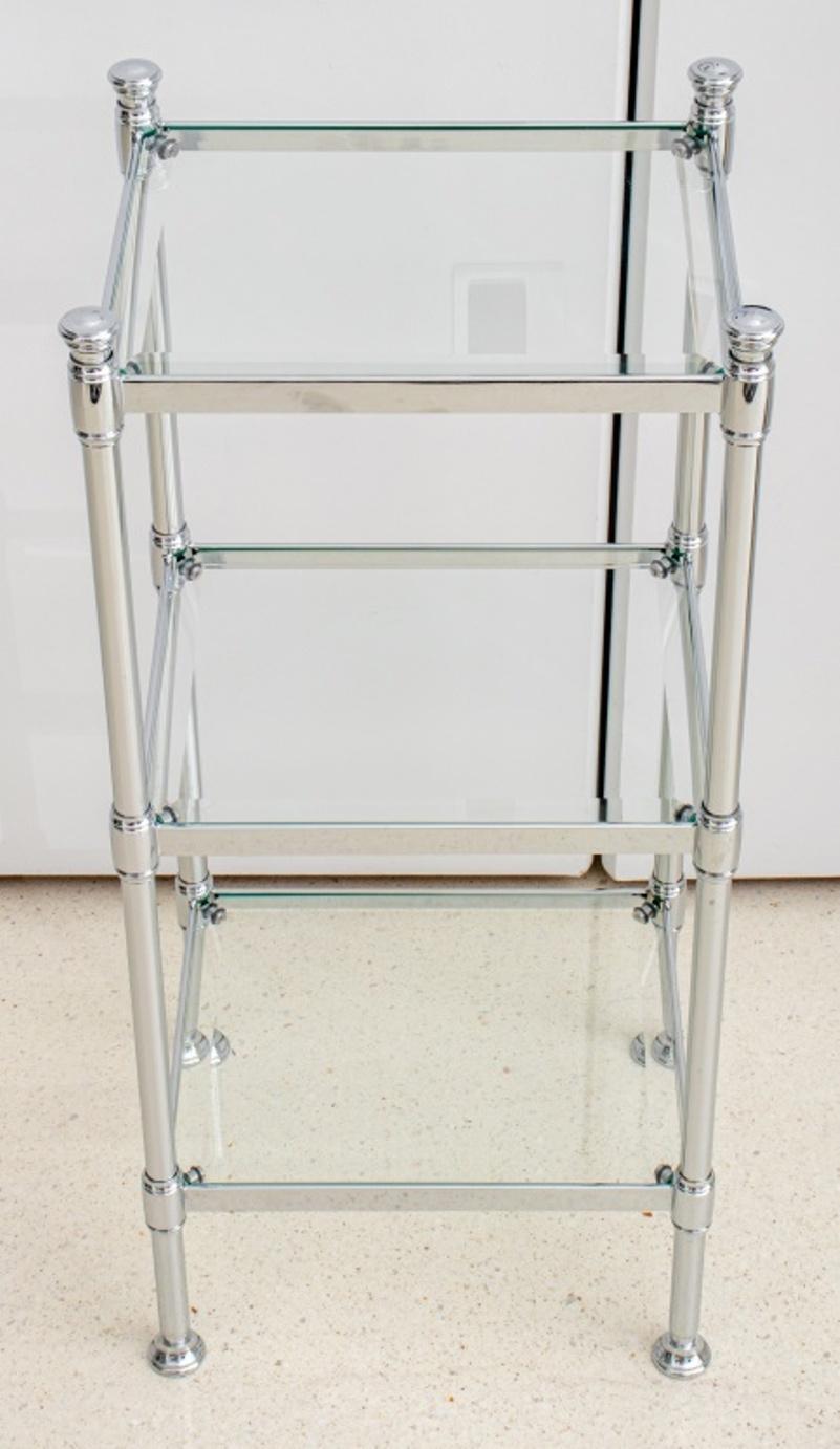 Maison Jensen style side table etagere, comprising of three shelves of chromed metal with glass inserts, unmarked. 28.25