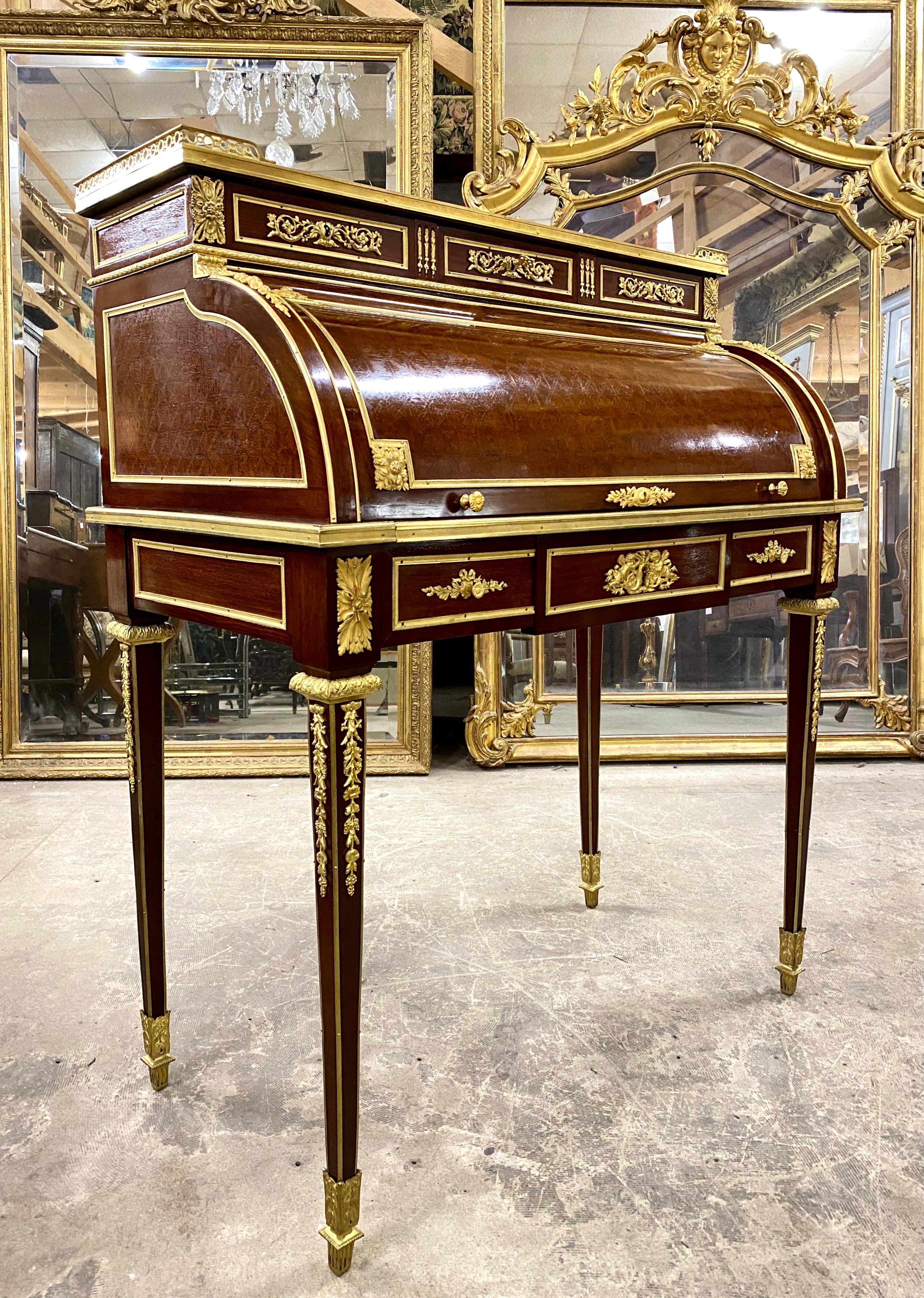 Cylinder desk surmounted by a tier, richly decorated with chiseled and gilded bronzes and a cube marquetry. It opens with three drawers in a belt locked with a central lock, as well as three other drawers at the level of the tier. The cylinder is