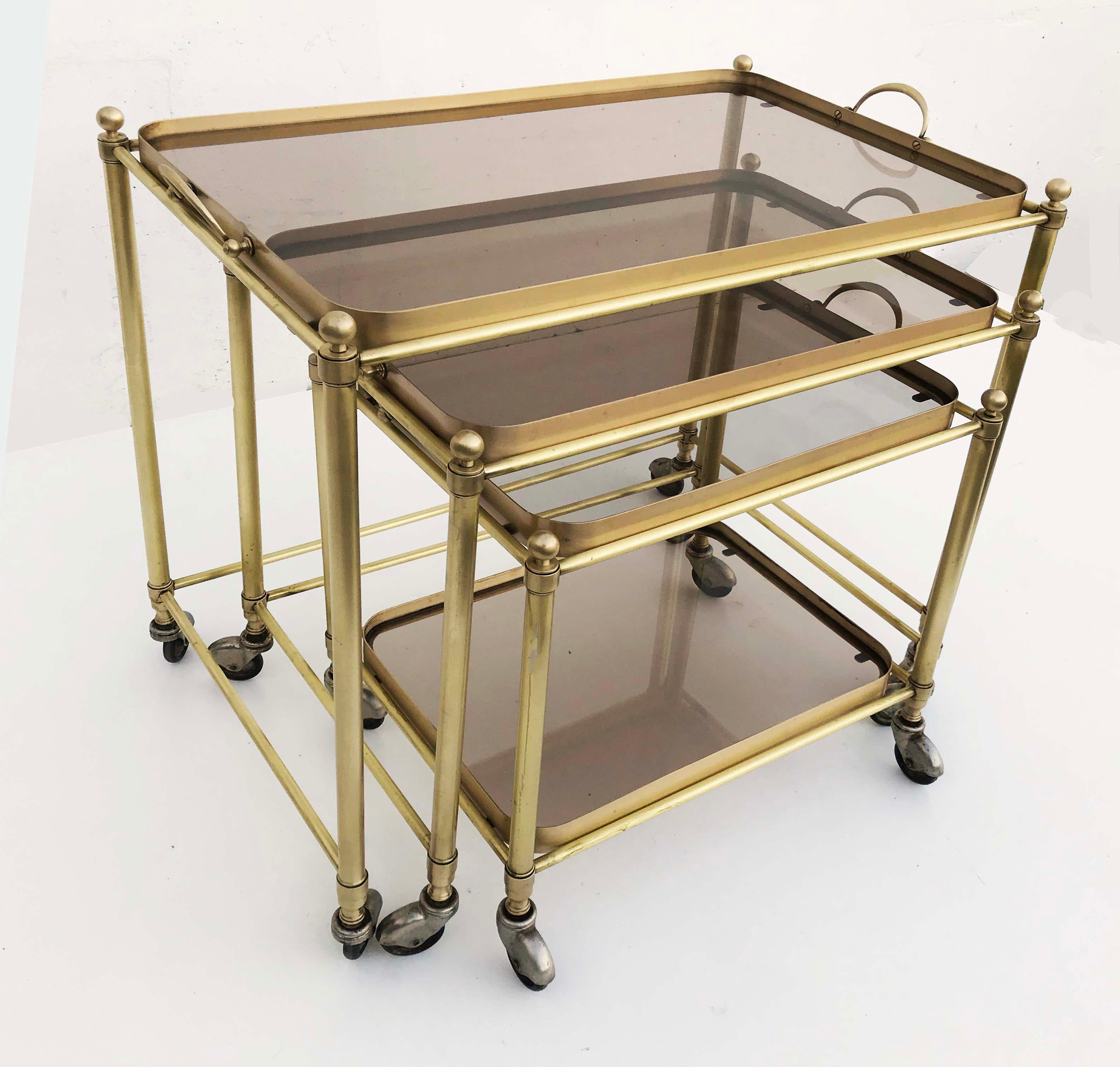 Superb set of Nesting table by Maison Lancel, each one with a removable tray.
 $ 2980 for the of tables
Bronze and smoke glass, all Table on wheels.
The smallest has two-tier.
Totally restored and refinished
Dimensions:
25 L /15 1/2 D / 24 H
21 L