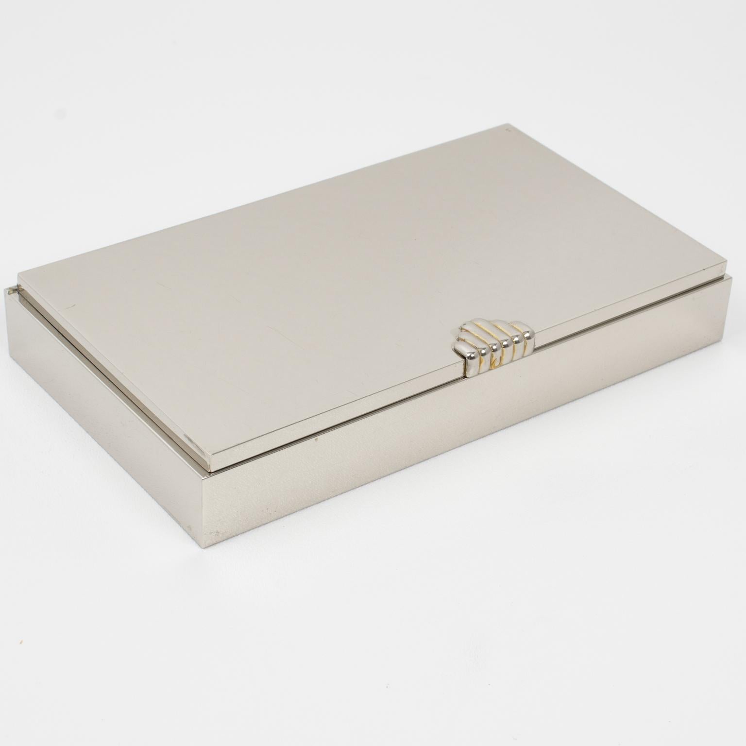 La Maison Lancel Paris a conçu et fabriqué cette élégante boîte décorative à couvercle dans les années 1980. La forme rectangulaire minimaliste présente un design épuré avec un métal chromé poli complété par une application plaquée or sur la poignée
