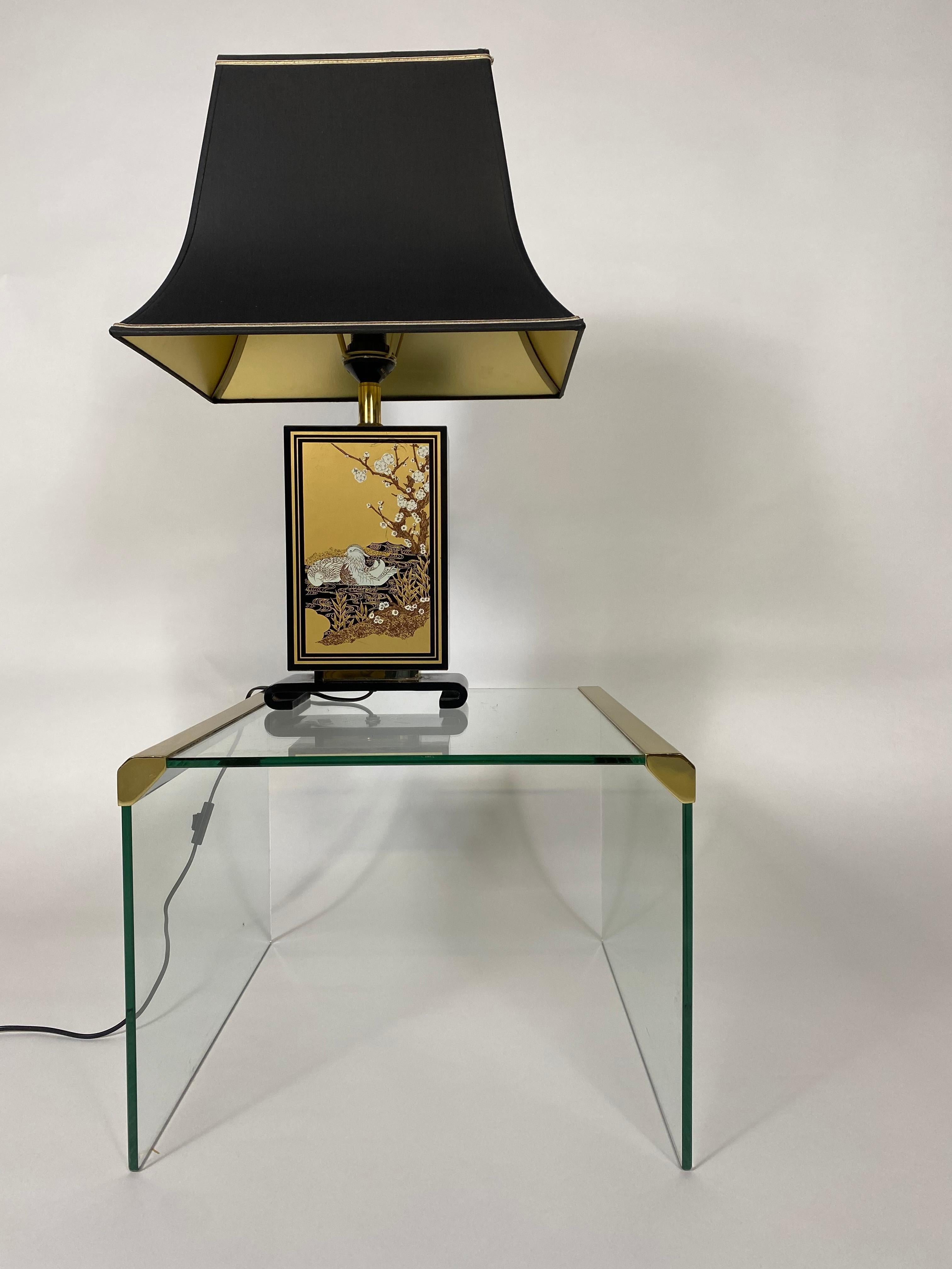 Hokkaido Tischleuchte im Mid-Century Modern Design mit geschwungenem, aufgerolltem Sockel aus schwarz lackiertem Holz. Schwarz lackierter Holzbalken mit goldfarbenen Elementen und einem Bild eines schwimmenden Mandarinentenpaares in einem Teich.
