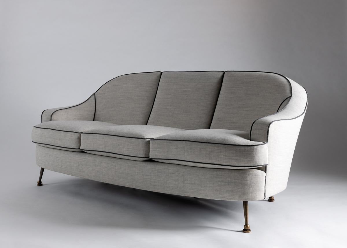 This charming midcentury Leleu sofa has beautiful sloping arms and playfully splayed brass and gun metal legs.

For an illustration of a similar model, see :
Leleu, 50 ans de mobilier et de decoration (1920-1970), catalogue
d'exposition (La Piscine,