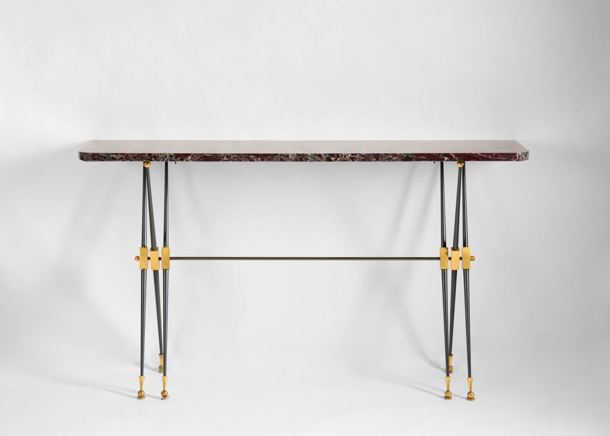 An elegantly pared down console with delicate crossing legs in gunmetal bronze, which, in supporting its marble top gives the piece the appearance of weightlessness.

Bibliography:
The House of Leleu: Classic French Style for a Modern World,