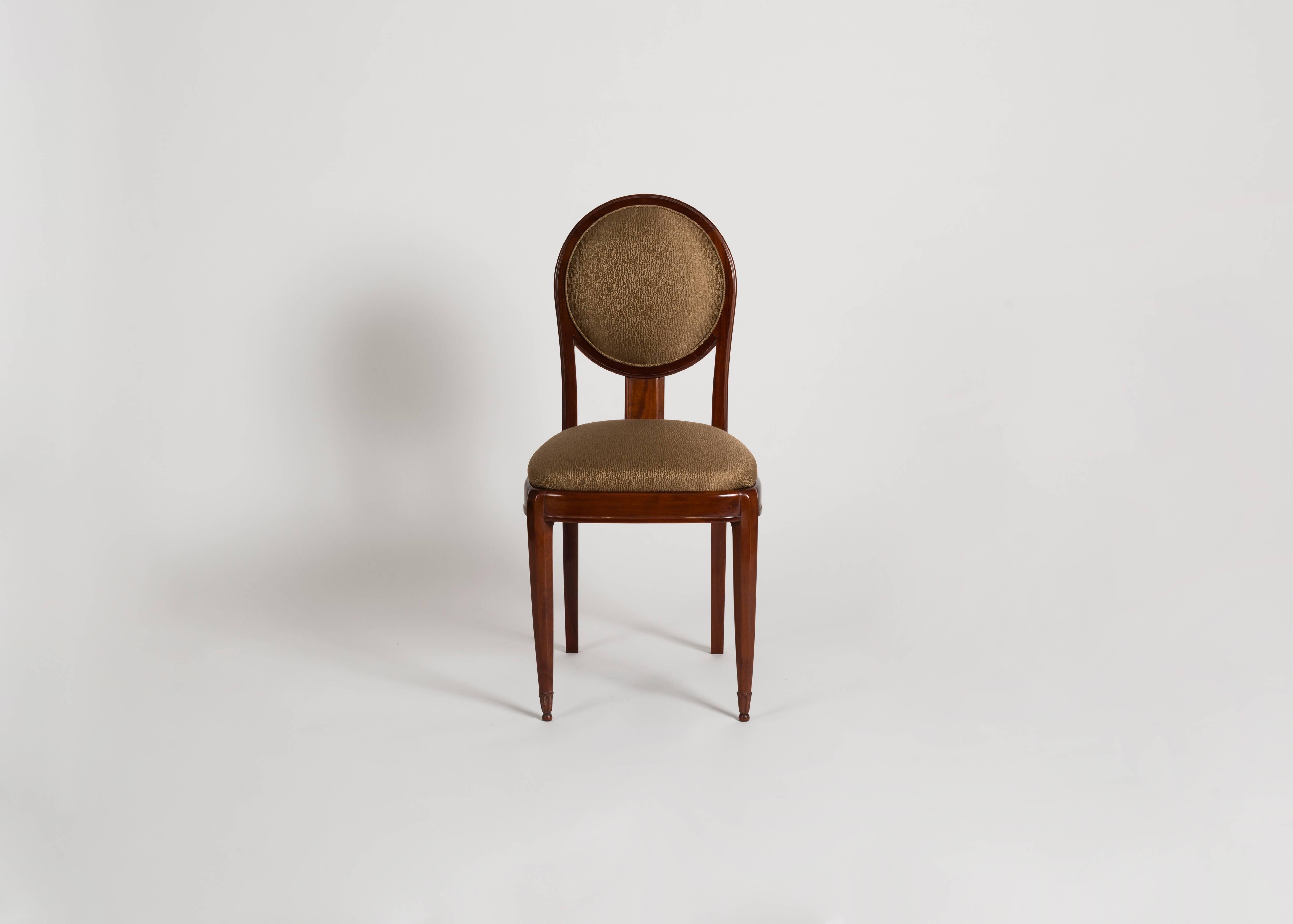 A midcentury walnut side chair designed by Jules Leleu with an elegant, tall back covered in a round upholstered cushion, and beautifully carved, tapered legs.