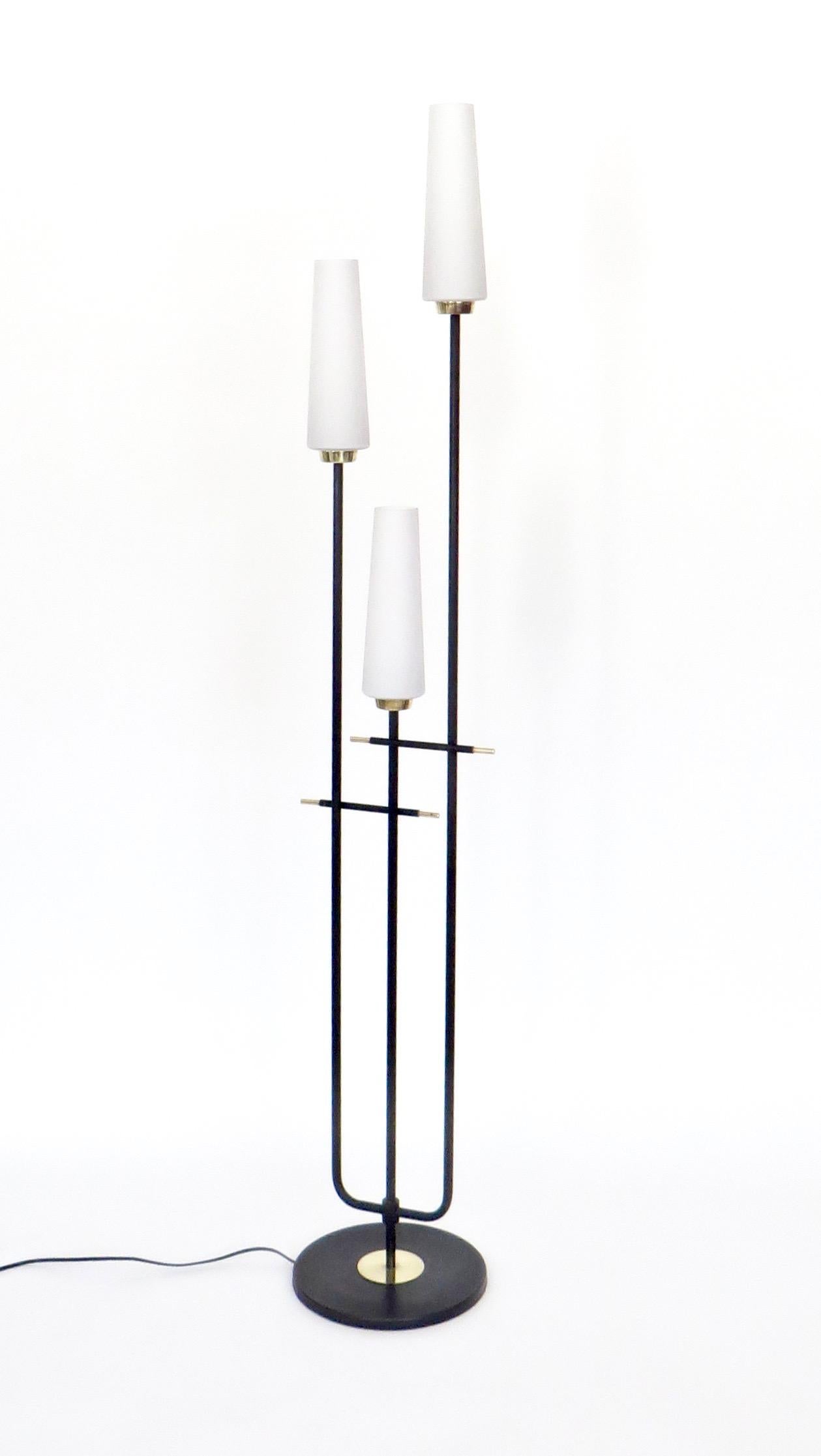 French floor lamp by Maison Lunel, black iron with brass accents, and three cased, blown glass shades. Rewired for USA. Takes candelabra base bulbs, 60w maximum.