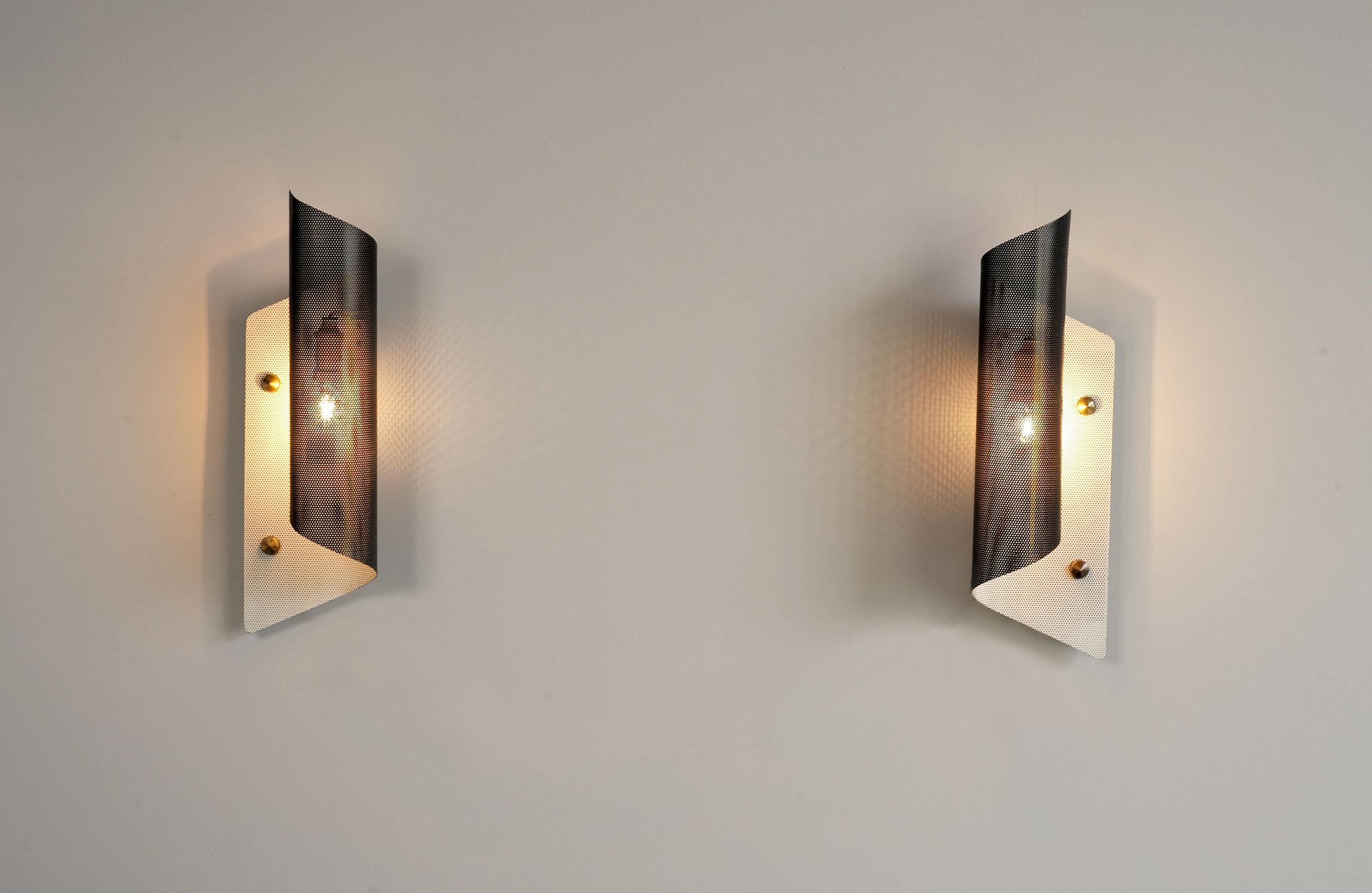 Rare pair of perforated metal sconces, black and white lacquered by Maison Lunel, France, 1950.
Adjustable at will, these sober and elegant luminaires produce a very pleasant light through the sieve perforations.
Very beautiful original state.