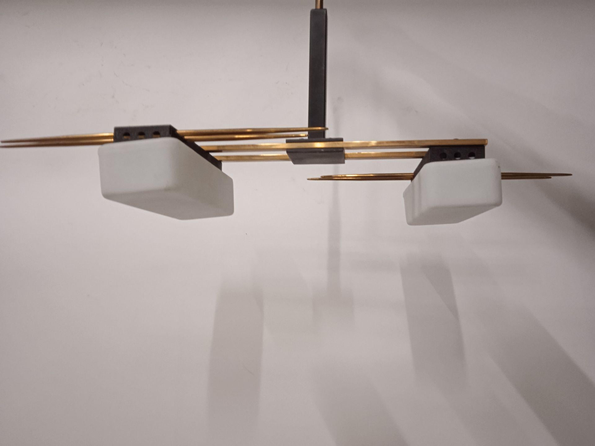 Suspension House LUNEL, around 1950

This elegant suspension, published by Maison Lunel, embodies the refined aesthetics of the design of the 1950s. Its structure in gilded brass and black lacquered metal reveals a harmonious marriage between the