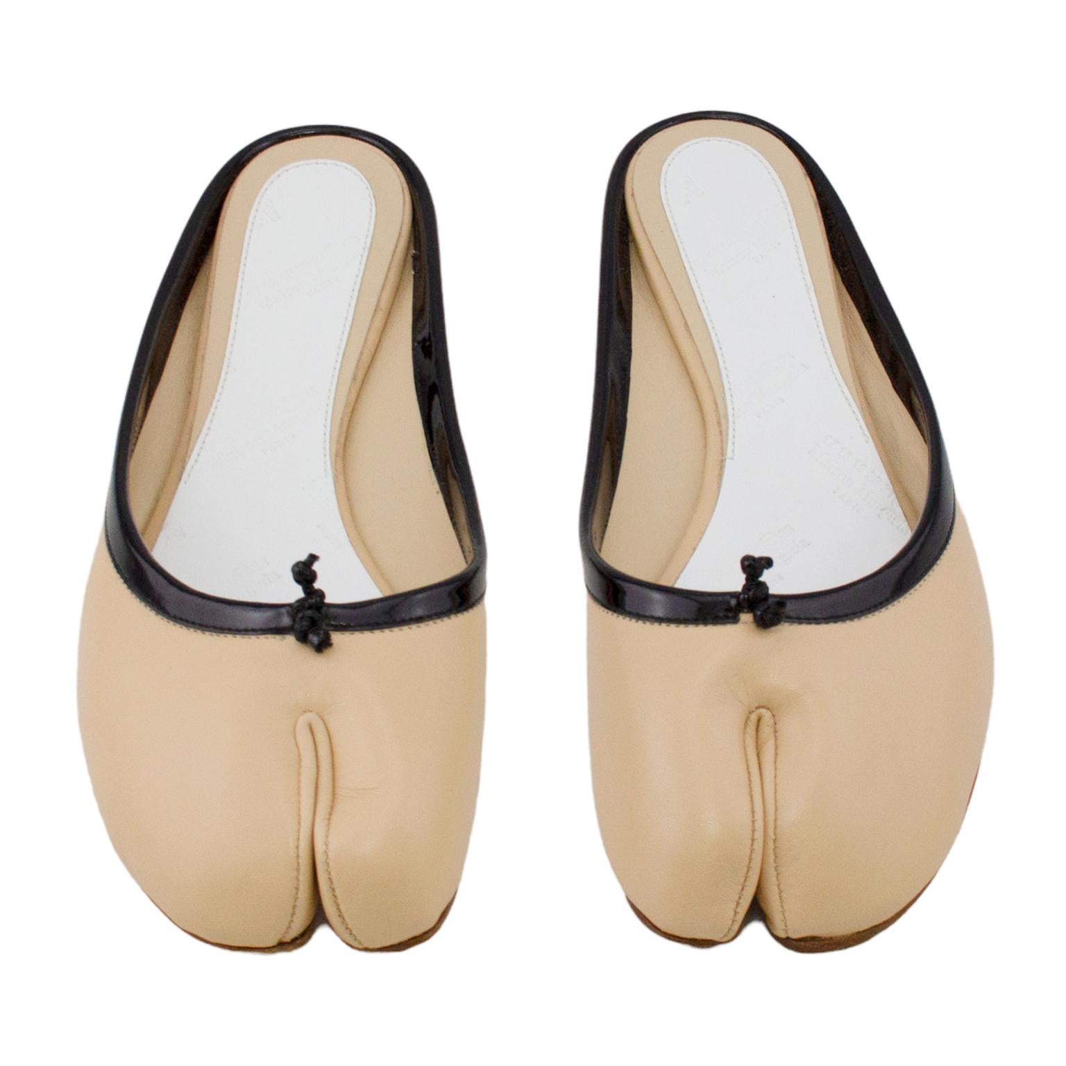 The iconic and hard to find Maison Margiela tabi slide. Supple beige leather with contrasting black patent leather trim. White brand stamped leather insoles with tonal stitching. Excellent vintage condition - very, very slight wear on soles. No box.
