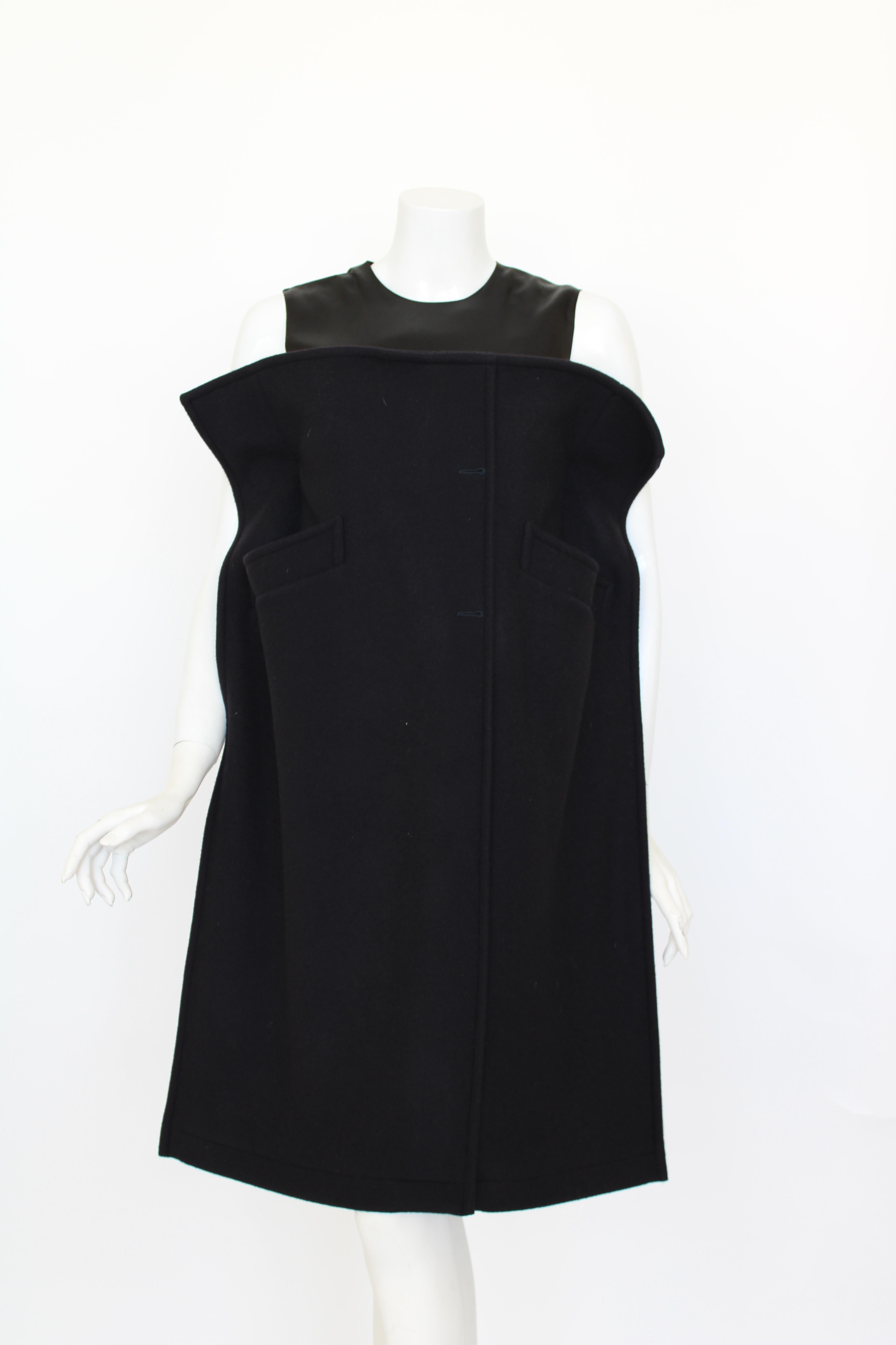 This silk and wool dress is reconstructed from a mans coat, with a silk upper and wool architectural lower half with coat pockets button holes.