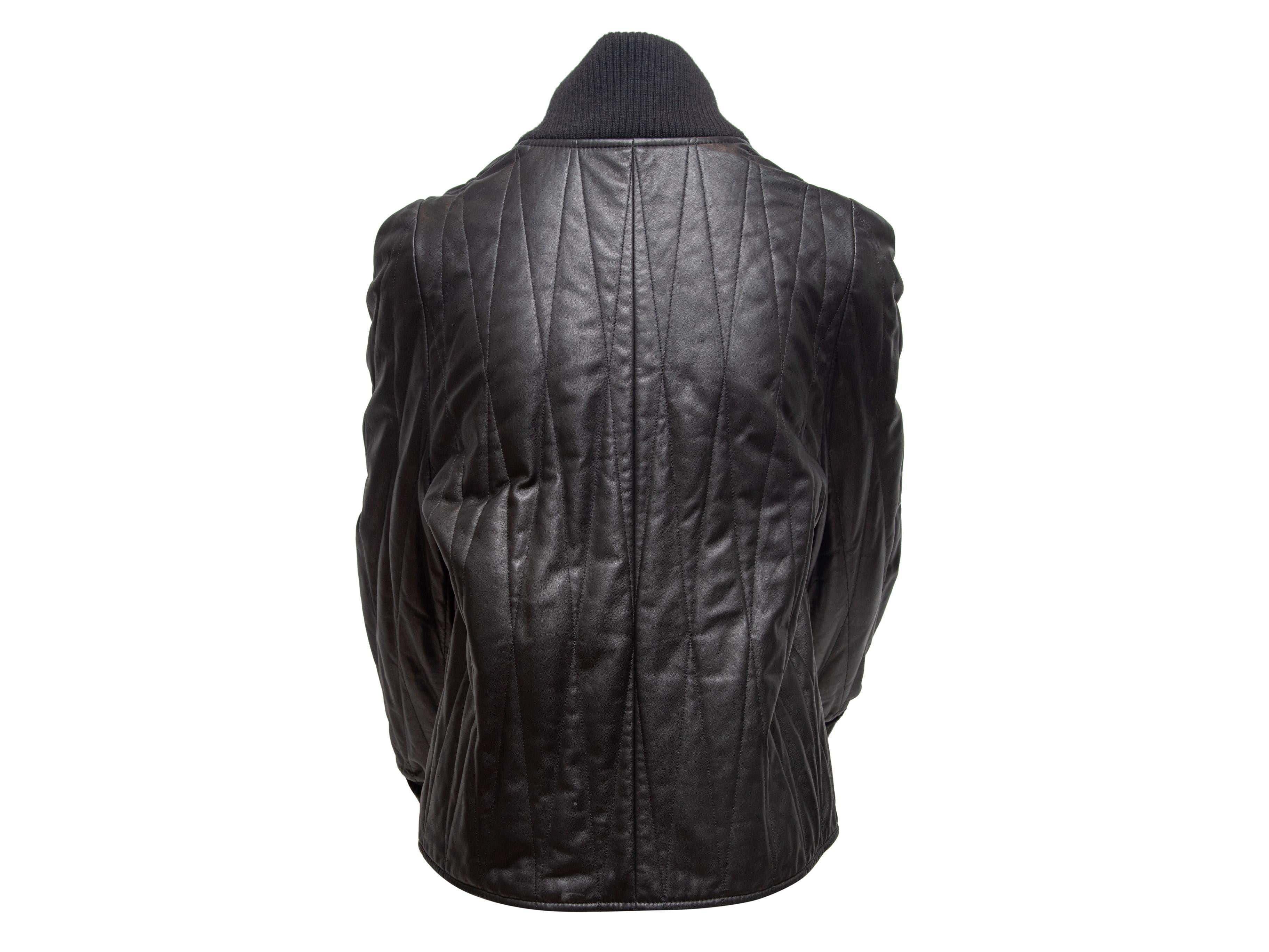 Product Details: Black quilted leather jacket by Maison Margiela. Rib knit trim at collar and cuffs. Dual hip pockets. Zip closure at center front. 32