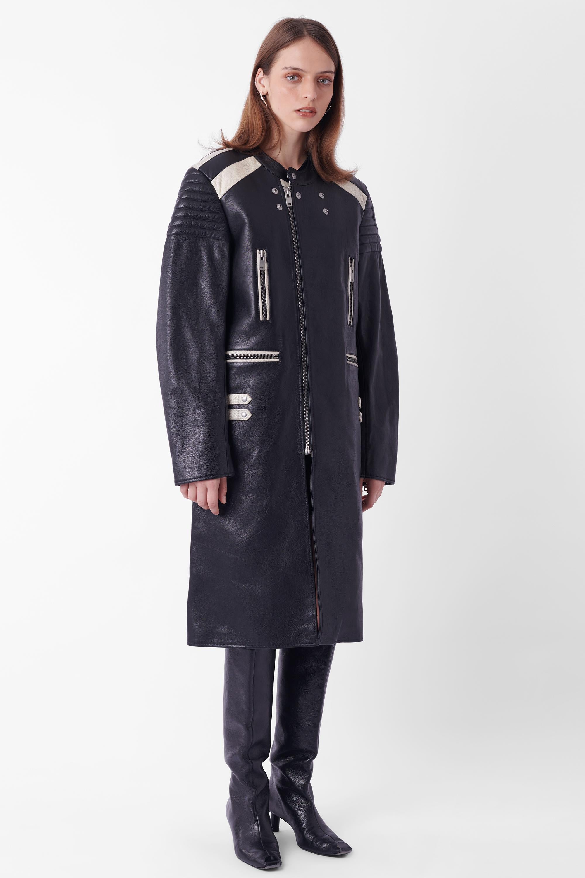 Maison Margiela Fall Winter 2016 black and white leather jacket, runway look 23. Features quilted shoulder  and elbow pads, chest and waist zip pockets, zips and sleeves, white adjustable hip fixtures,  zip front closure and oversized fit. Black and