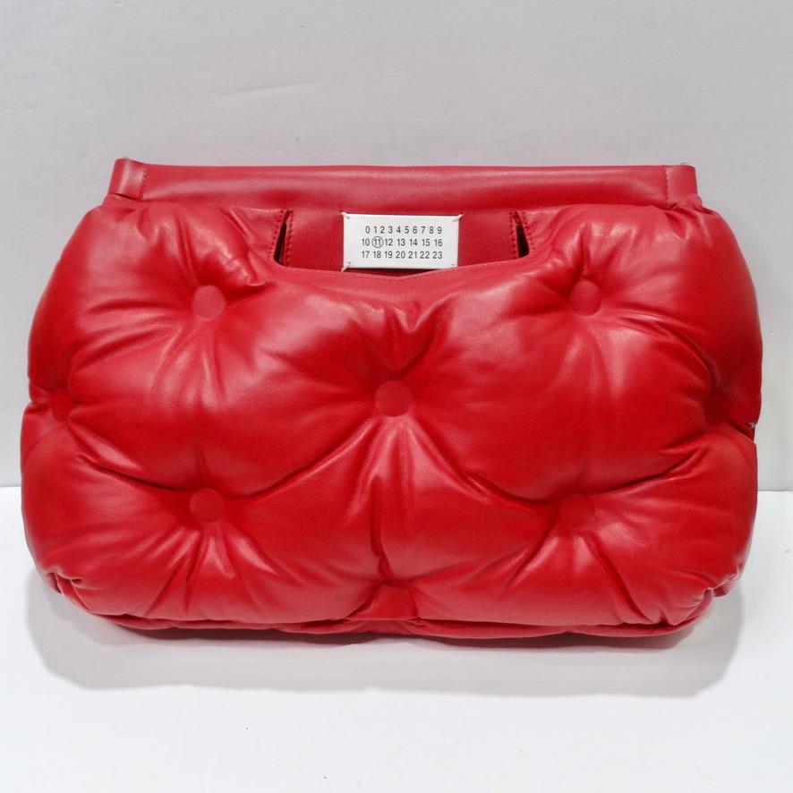 Calling all Margiela lovers! This iconic Maison Margiela puffer motif handbag is begging to be added to your collection! The most unique handbag in an eye catching padded bright red lambskin leather features a magnetic clasp closure and a removable