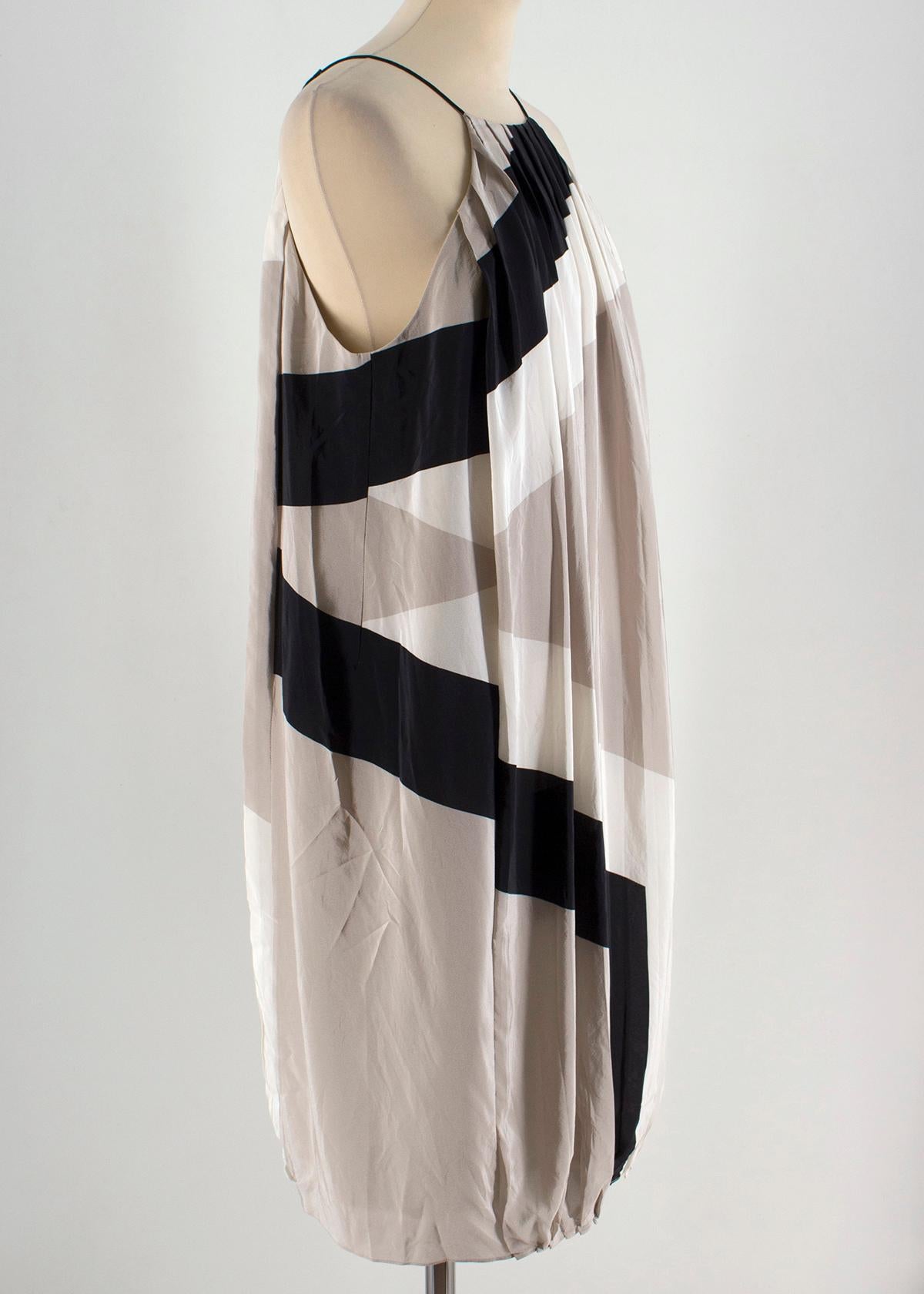 Tibi Pleated Colour-Block Silk-Chiffon Dress

- Tibi silk nude, grey and black shift dress. 
- Small V neck with lace tie-up.
- Pleated design with an asymmetrical stripe across the body.
- Gathered hem creating a puffed look. 
- Silk
