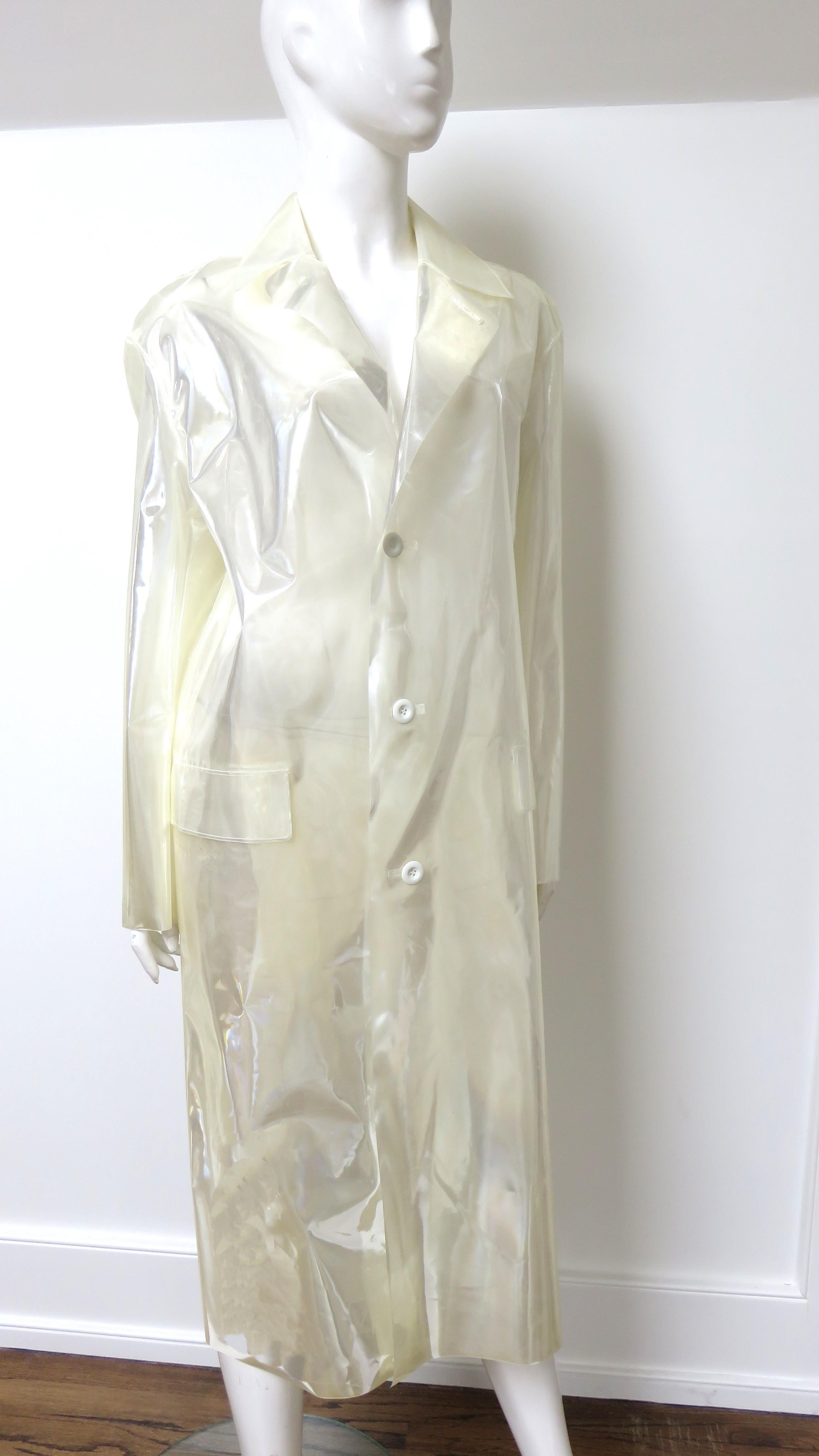 A fabulous new translucent, white reflective polyurethane plastic raincoat from Maison Margiela S/S 2018 collection. It was difficult to capture the beautiful white reflectiveness in photos, it has a lapel collar which can be buttoned closed at the