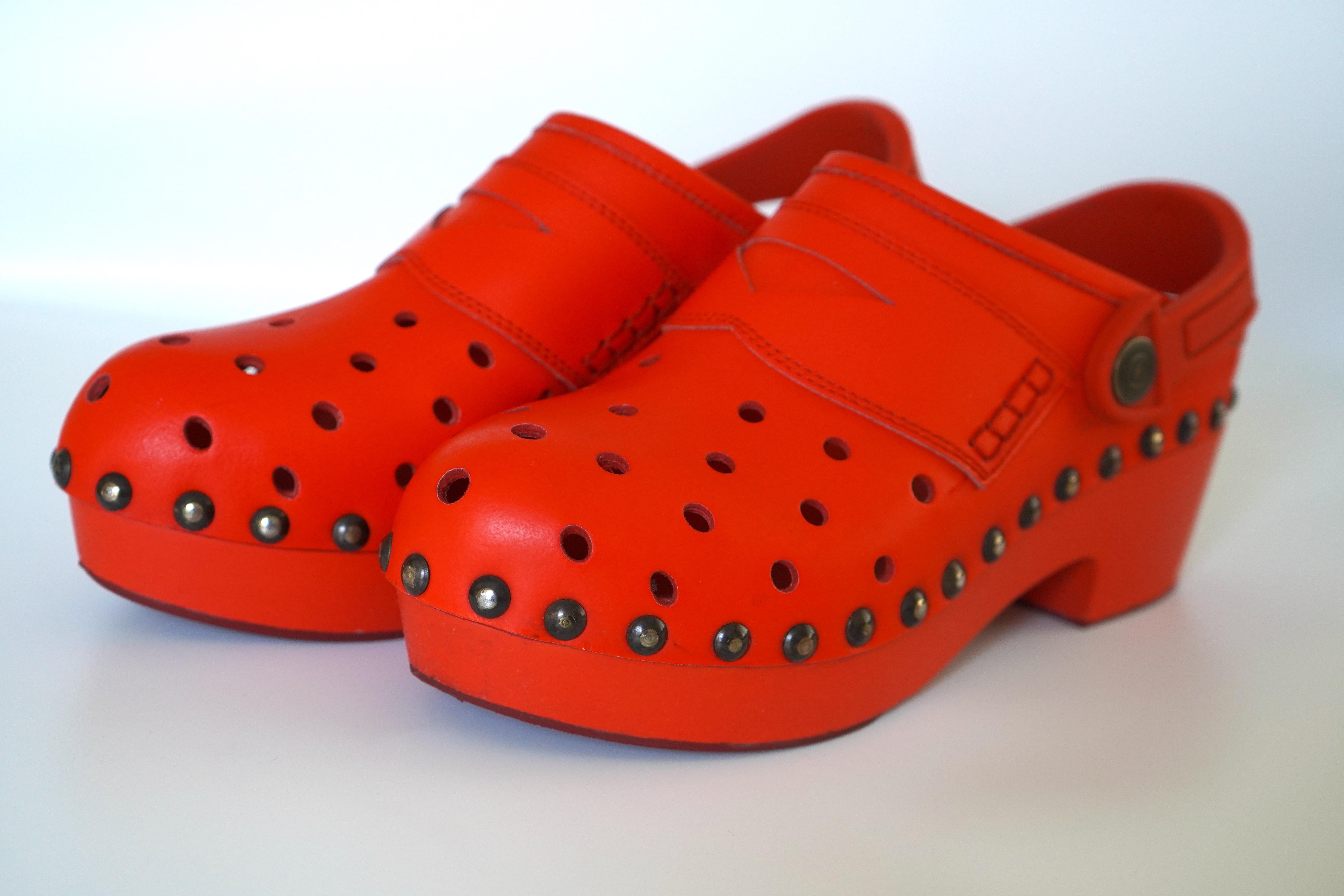 Maison Margiela Red Leather Platform Croc Clogs in size 39. These shoes feature perforated leather similar to the look of Crocs, but with the style of clogs. They also have studs along the shoe where the platform and sole of the shoe meet. They come