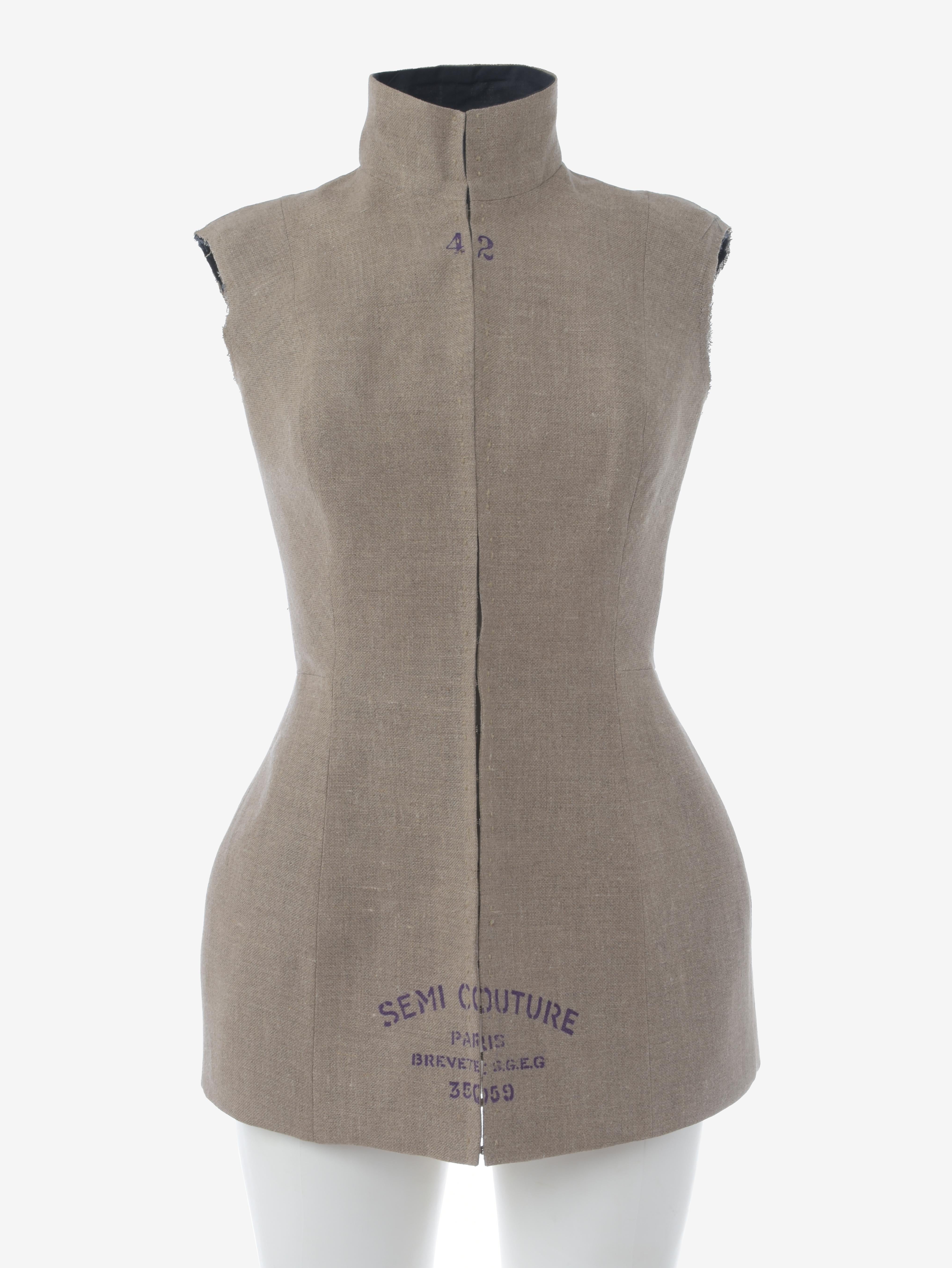 Maison Margiela Semi Couture Dressmaker Bodice is a rare and important original Maison Martin Margiela high-collar Semi Couture dressmaker bodice from 1997. The Semi Couture bodice features a high collar, front closure with frogs  and  printed