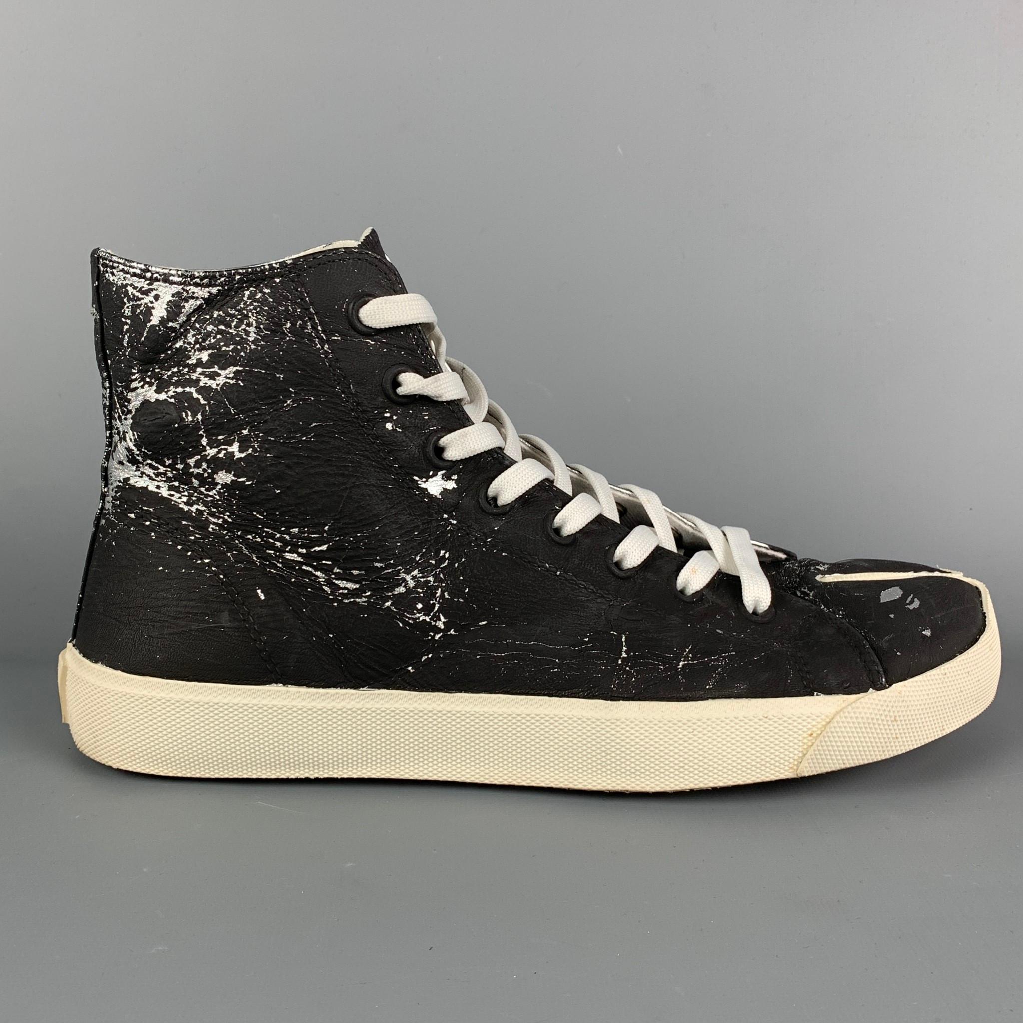 MAISON MARGIELA 'Tabi' sneakers comes in a black & silver painted canvas featuring a high top style, signature split toe design, rubber sole, and a lace up closure. Made in Italy. Includes box. 

Excellent Pre-Owned Condition.
Marked: 43

Outsole: