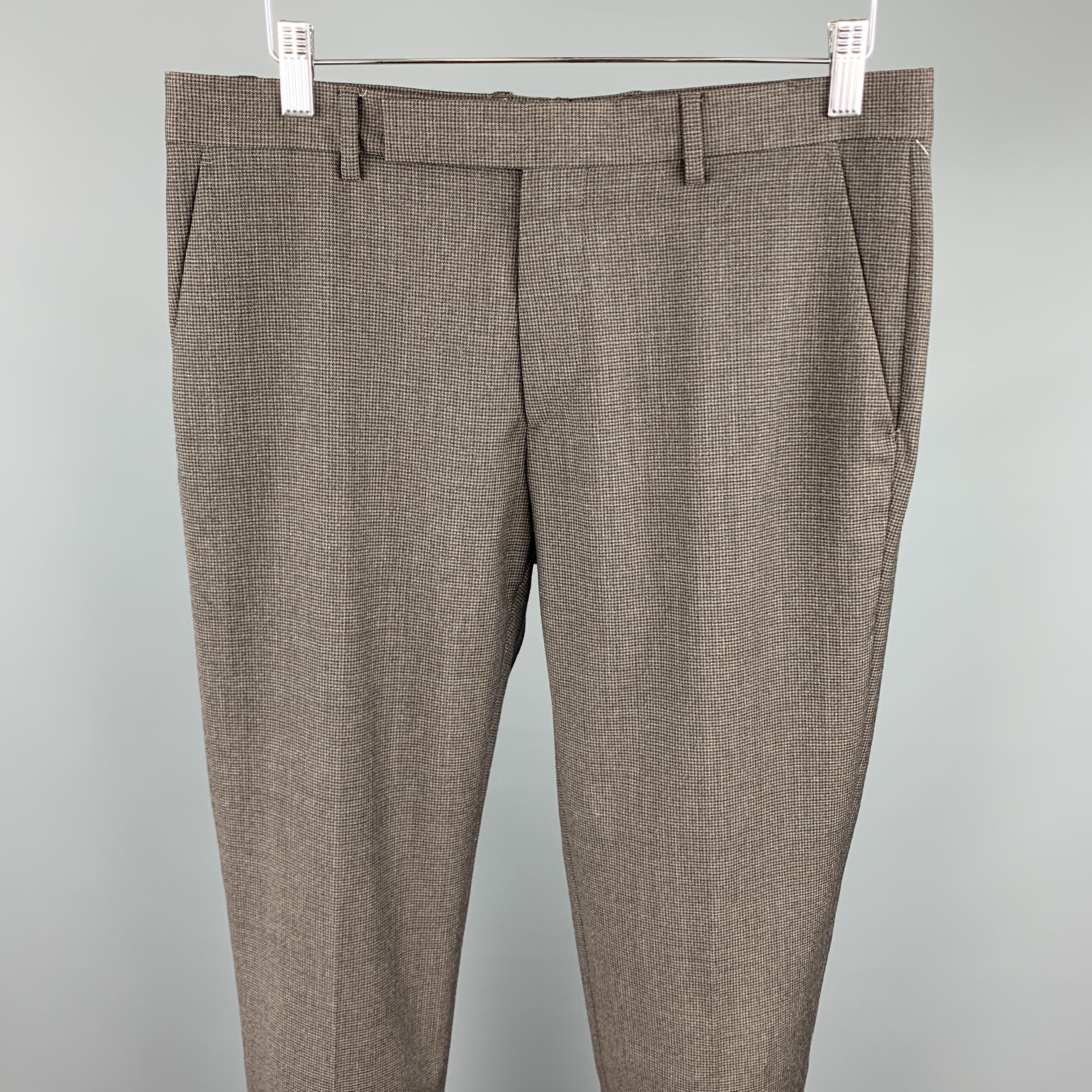 MAISON MARGIELA dress pants comes in a dark brown houndstooth featuring a slim fit and a zip fly closure. Made in Romania.

Excellent Pre-Owned Condition.
Marked: 48

Measurements:

Waist: 32 in.
Rise: 9 in.
Inseam: 34 in. 