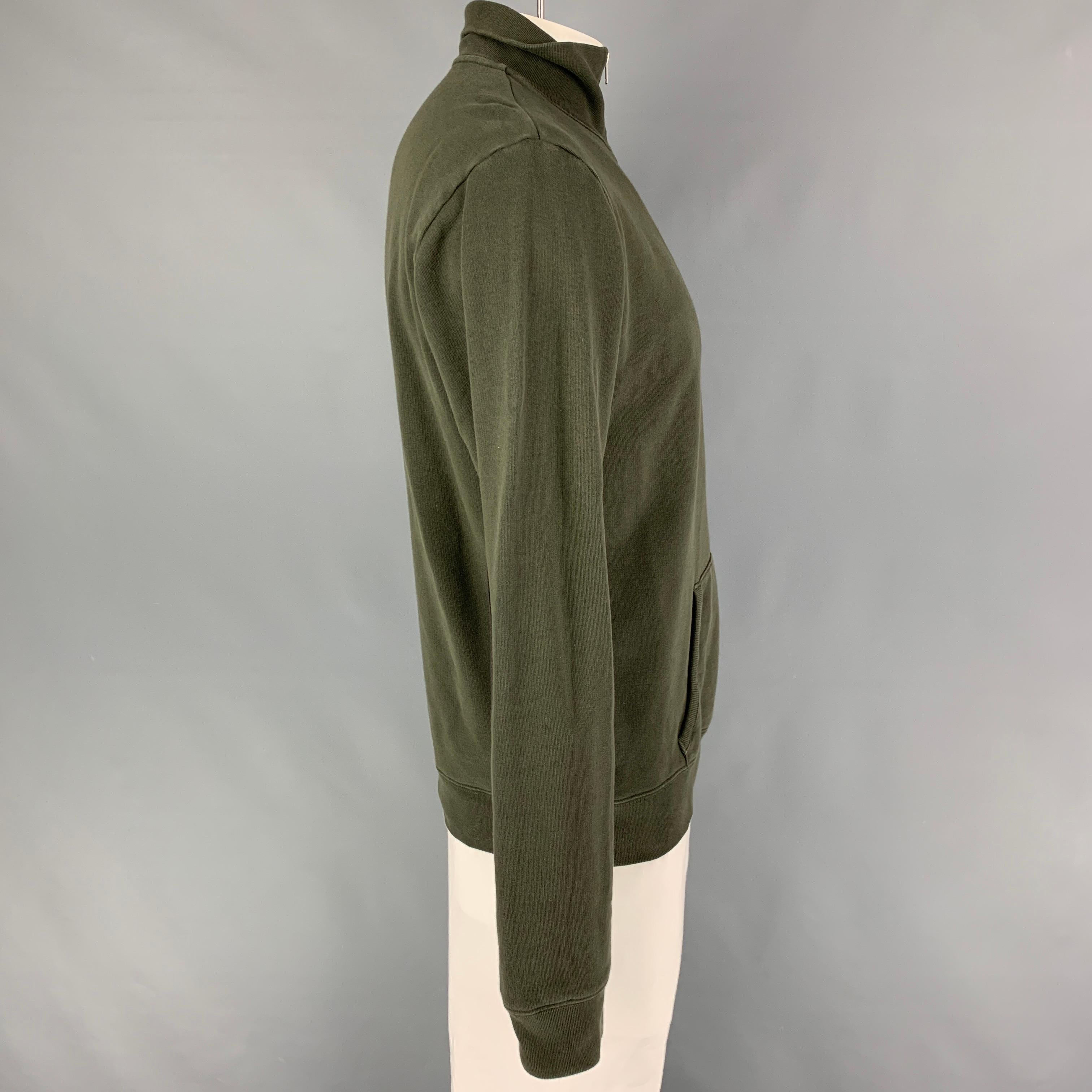 MAISON MARGIELA jacket comes in a olive cotton featuring a high collar, leather elbow patches, front pocket, and a half zip up closure. Made in Italy. 

Good Pre-Owned Condition. Moderate discoloration at front.
Marked: 52

Measurements:

Shoulder: