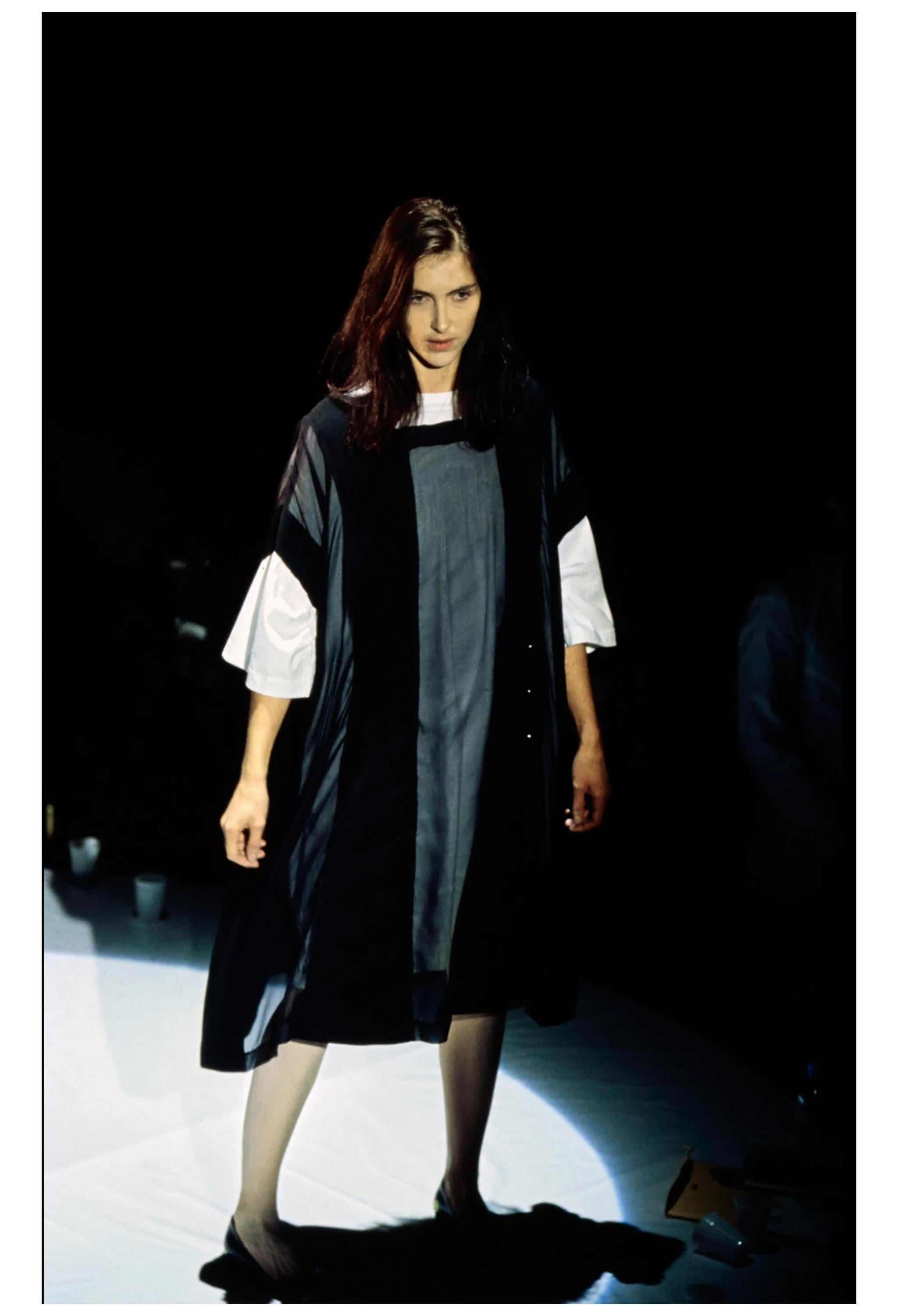 Resurrection Vintage est heureux d'offrir une robe noire artisanale vintage de Maison Martin Martin construite en utilisant une robe vintage à double maille et des panneaux transparents. Il s'agit d'une pièce unique issue de la célèbre collection