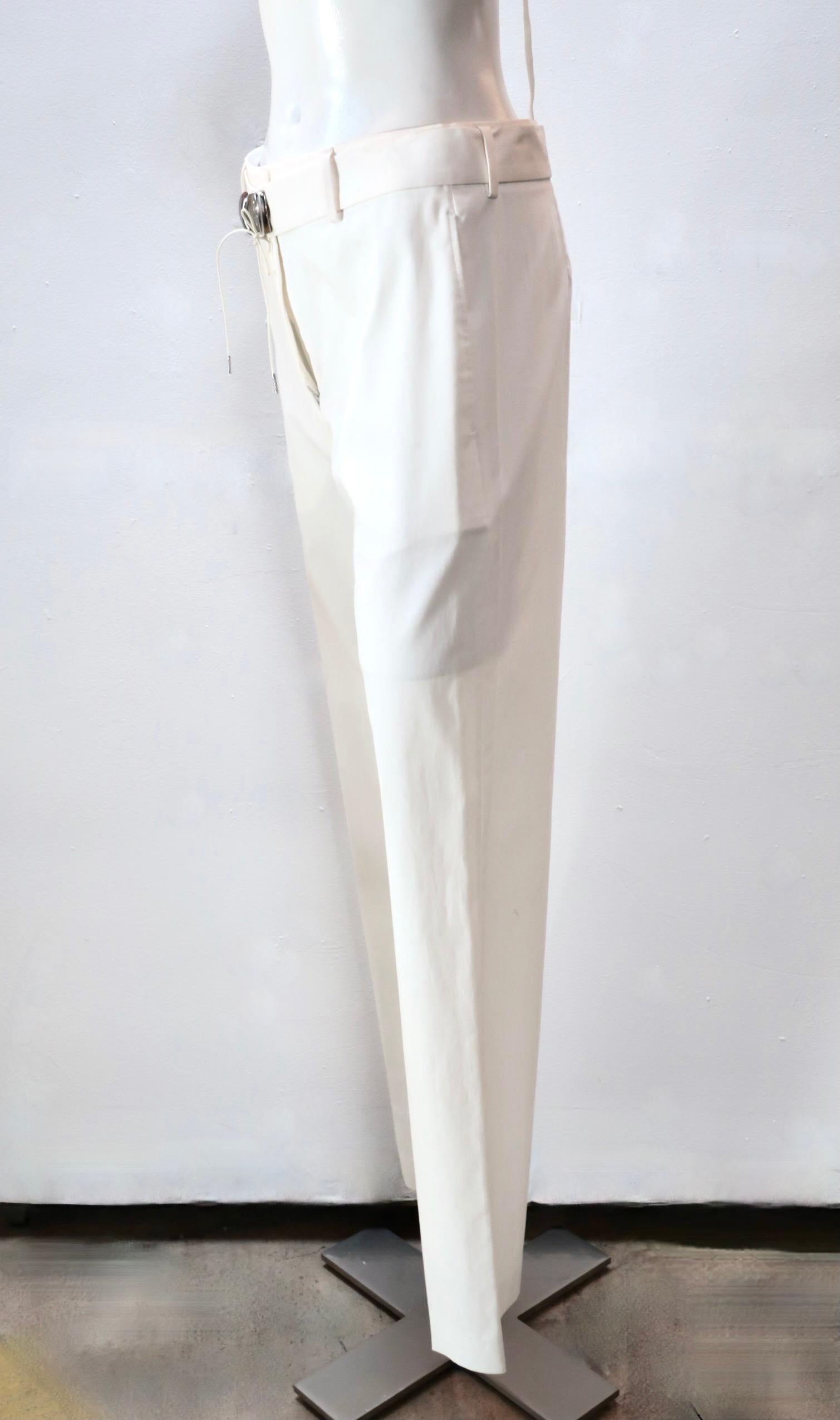 These elegant cream-colored straight leg pants from Maison Martin Margiela are belted, with opposing buckles that secure with a wrap-around strap. Two front seam pockets.