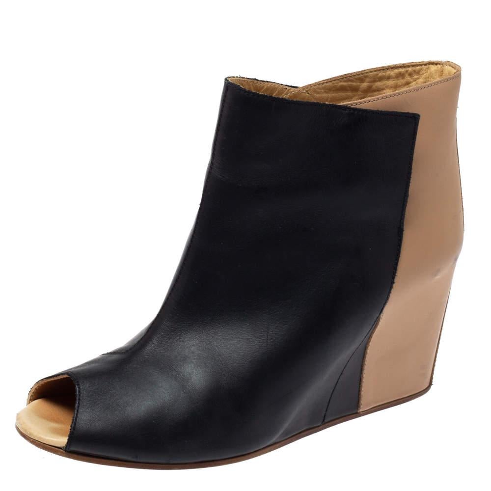 These peep-toe boots by Maison Martin Margiela provide high style that speaks volumes without saying a word. Crafted from black and beige-hued leather, this peep-toe pair features comfortable insoles and wedge heels. 