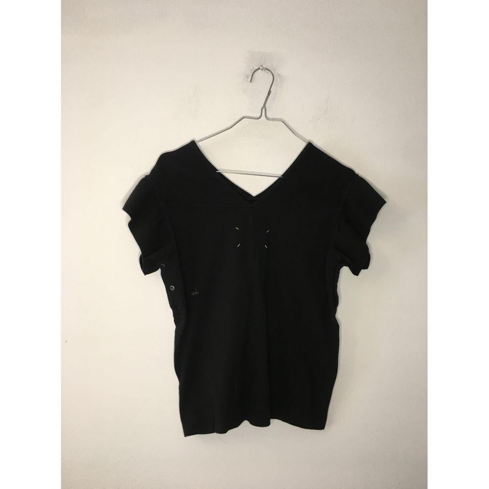 Maison Martin Margiela Black Cotton Top

Margiela T-shirt. In black cotton. 
International size L. But it fits small. 
Measures 42 cm at the shoulders, 44 cm at the bust and 55 cm in length. 
Created by joining two polo shirts. The polo collar forms